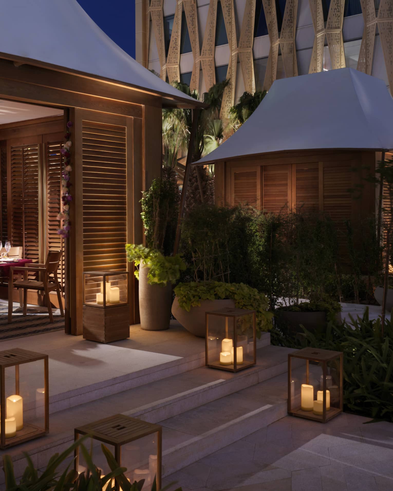 A series of lanterns illuminating the steps into a private bungalow