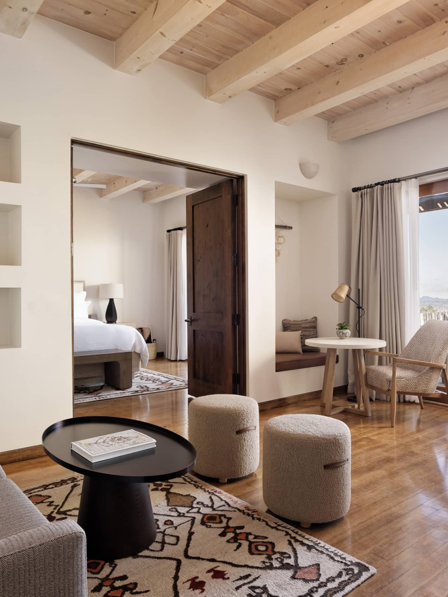 A living room in a suite with a couch and coffee table, and hammock on the patio