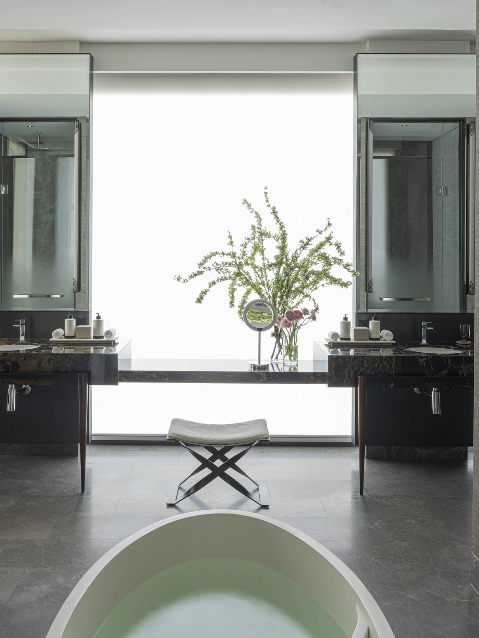 Luxury bathroom with standalone tub and two hanging bathrobes