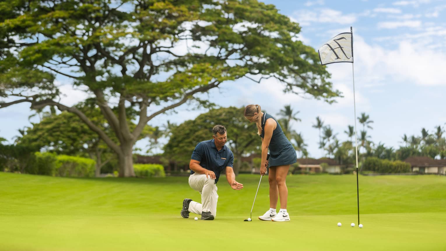 A woman practices her putting during a golf lesson.