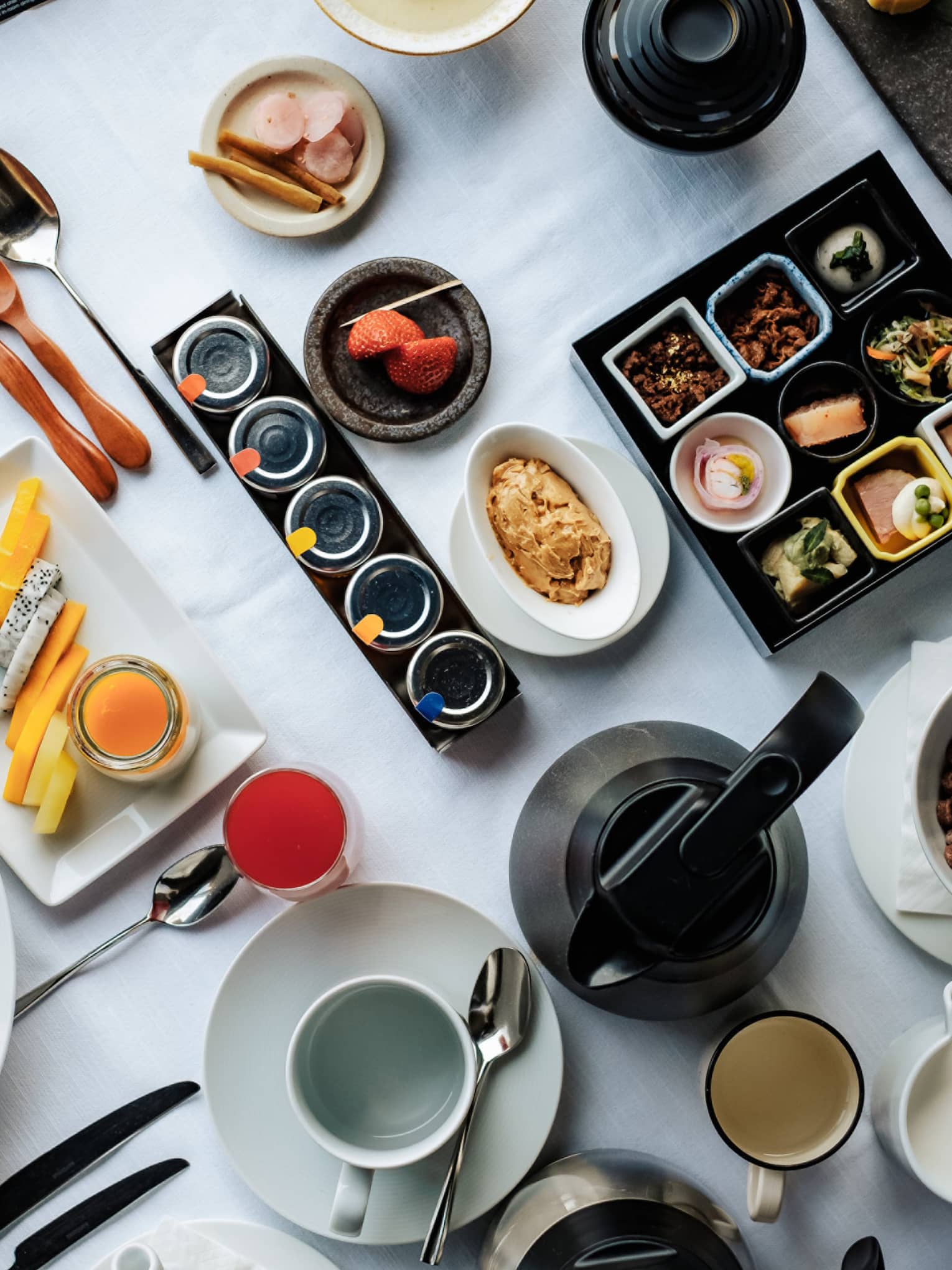 A wide array of Japanese and western-style breakfast foods, including eggs Benedict, assorted cheeses and sides