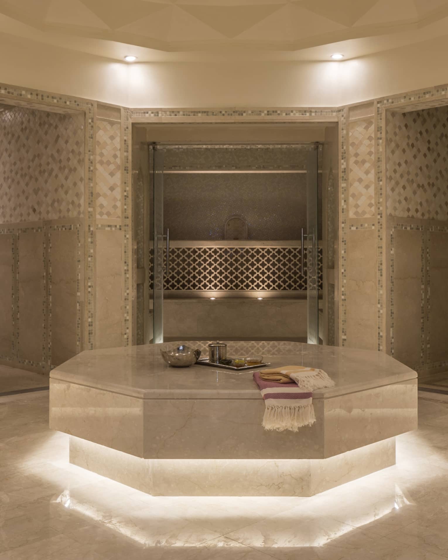 Hammam room with illuminated under lighting, beige marble