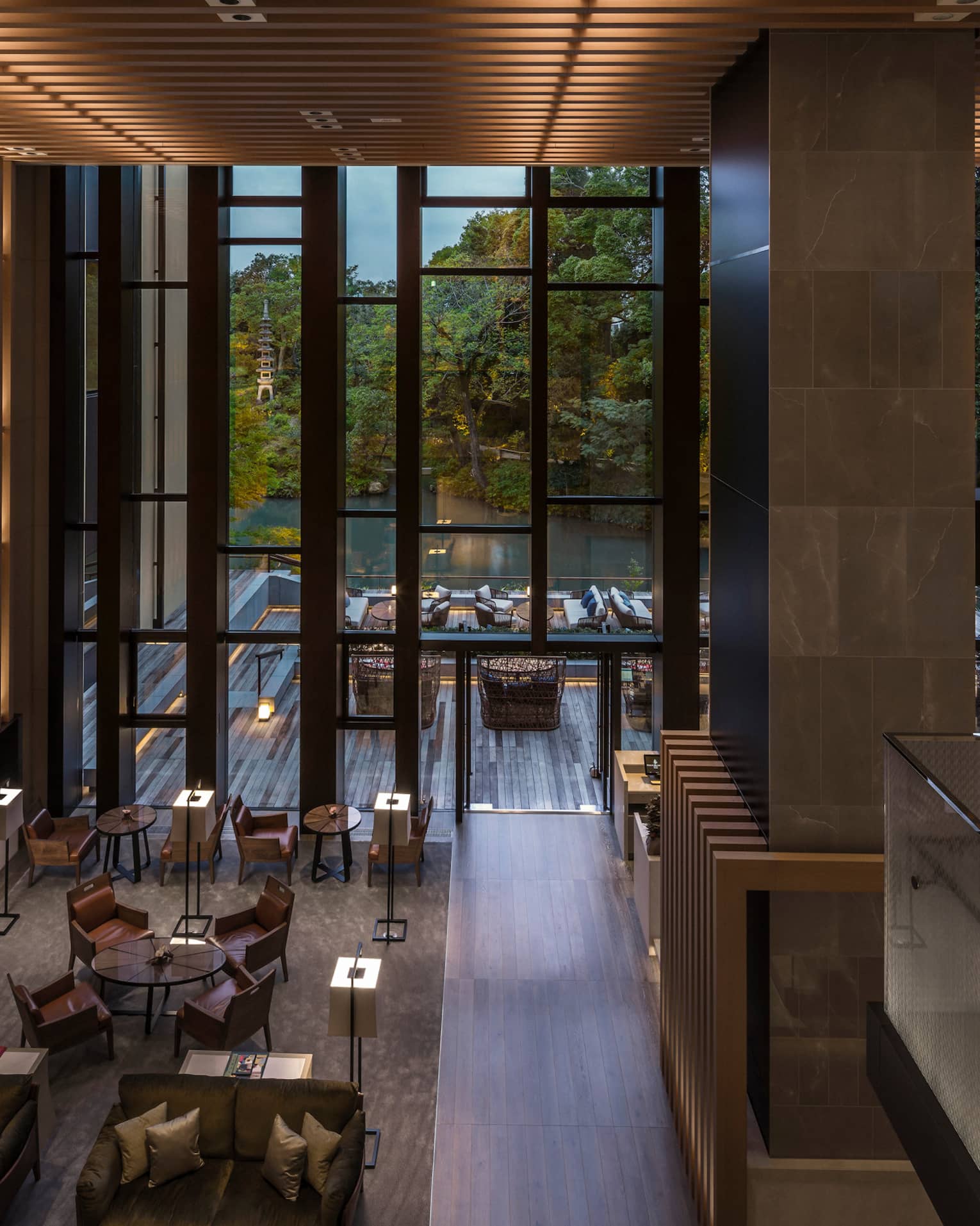 Looking down from soaring ceilings over Brasserie restaurant dining room, wood wall with lights