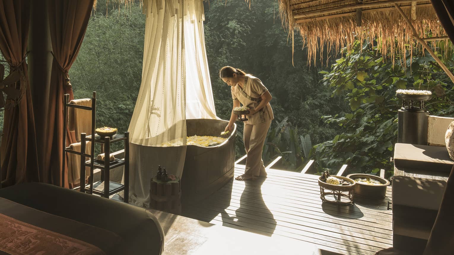 Woman prepares a bath on the jungle terrace