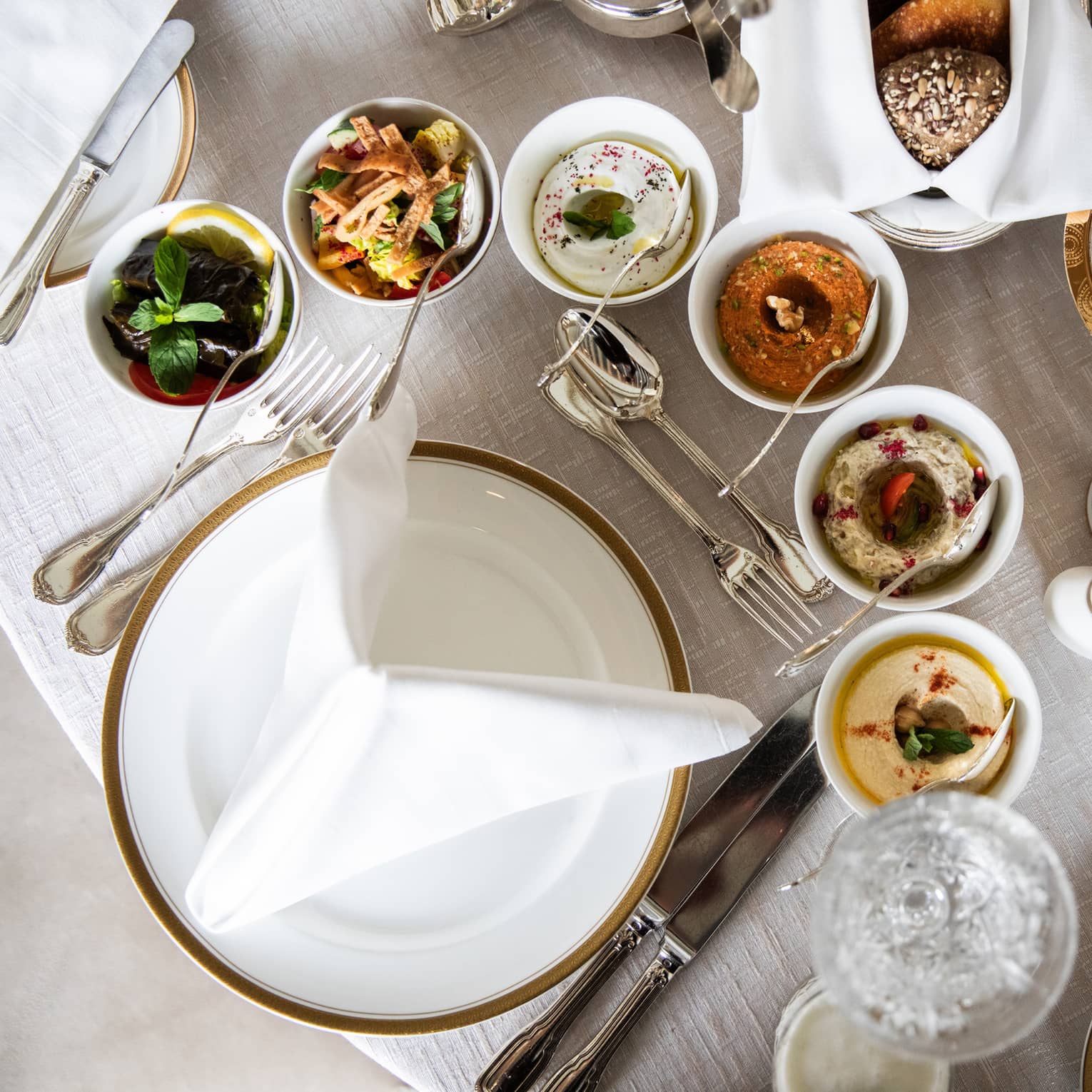 Aerial view of table with assorted Ramadan dishes in silver and ceramic dishes