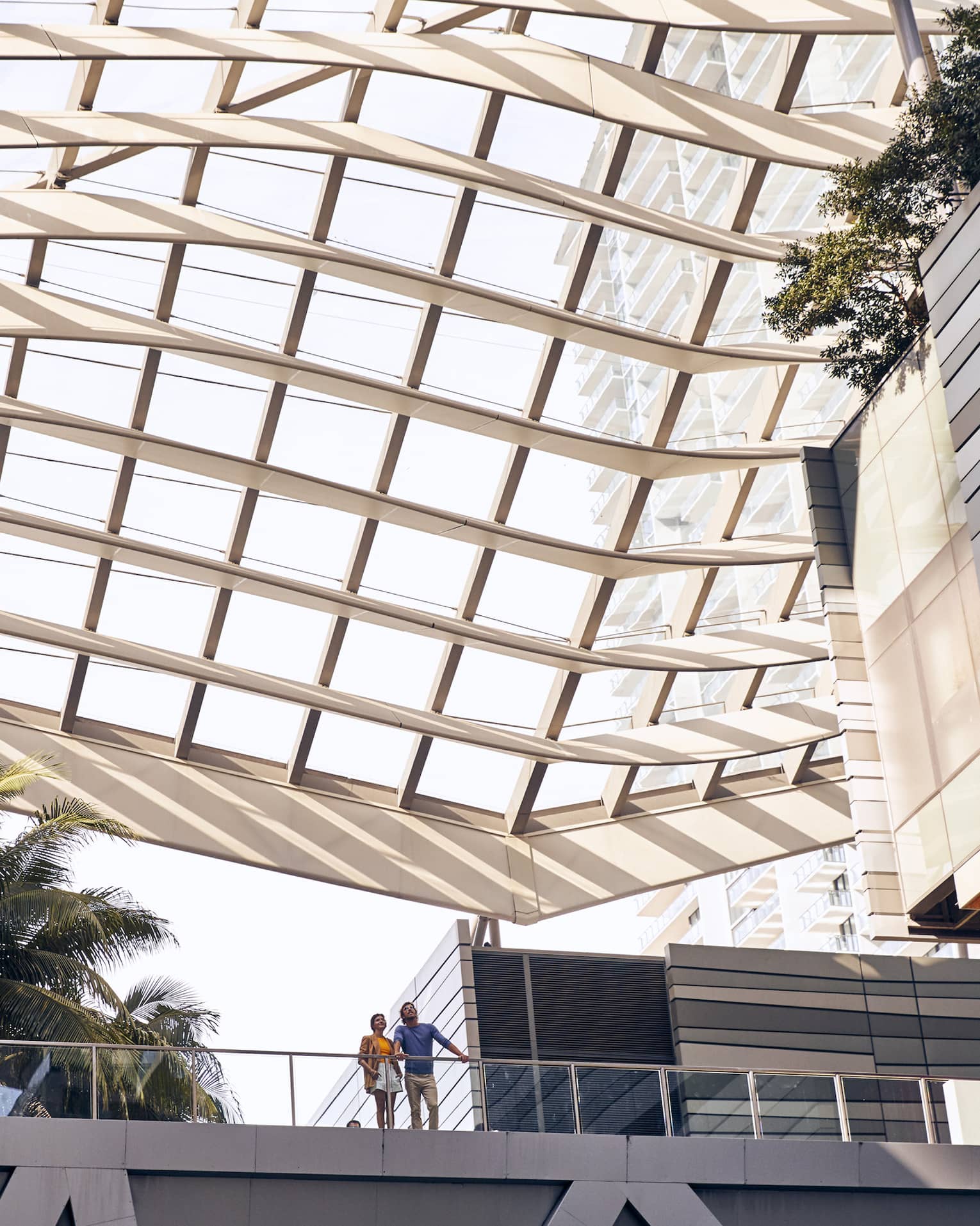 Outdoor walkway under modern grid-like, glass covering