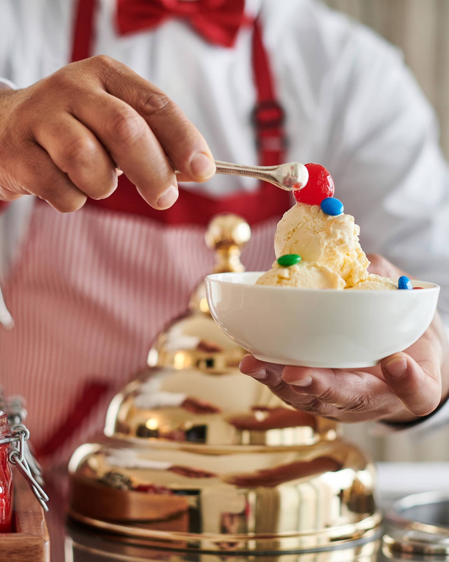 Man making an ice cream sundae from a retro Ice Cream Cart