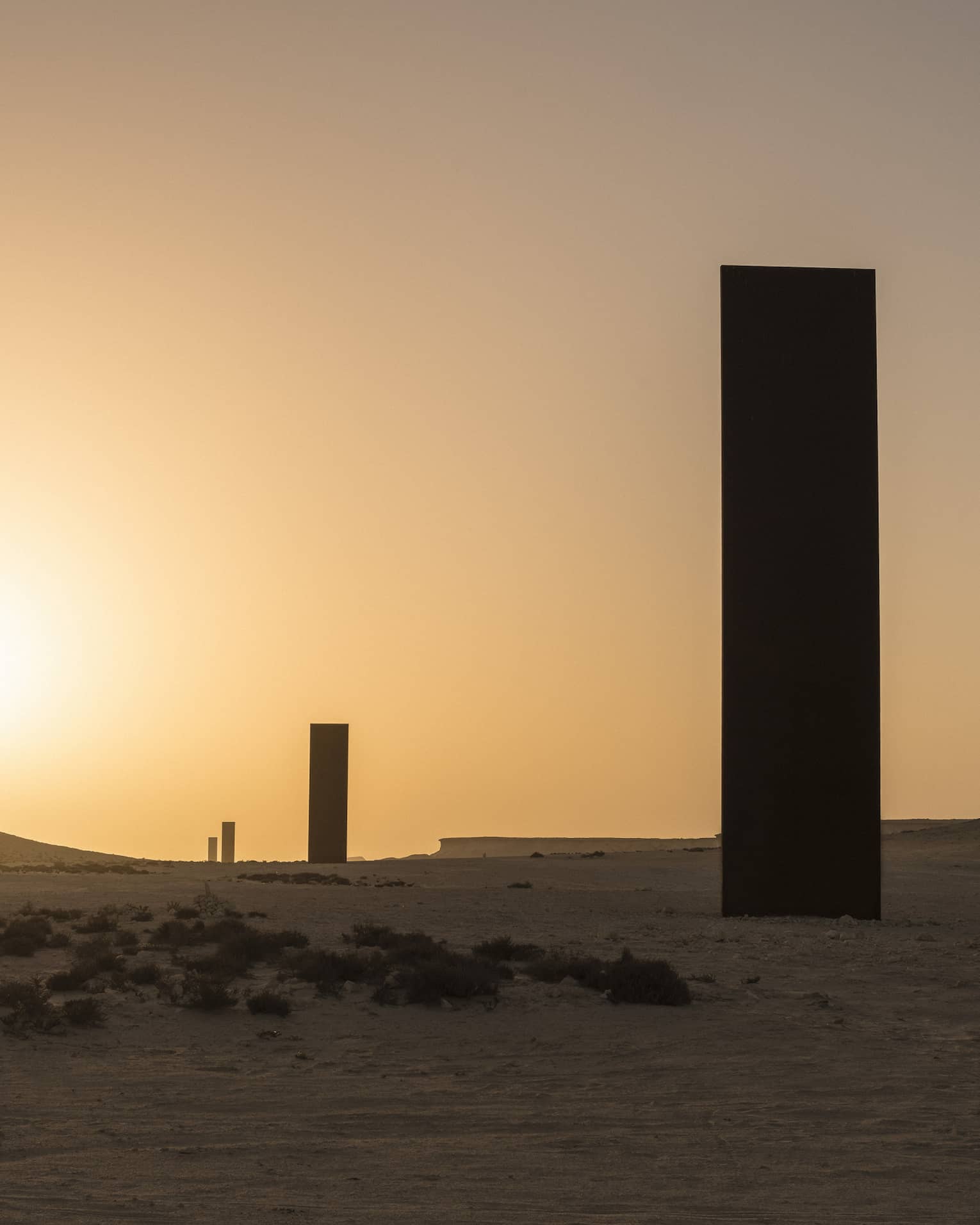 Silhouettes of Richard Serra Sculpture against sunset