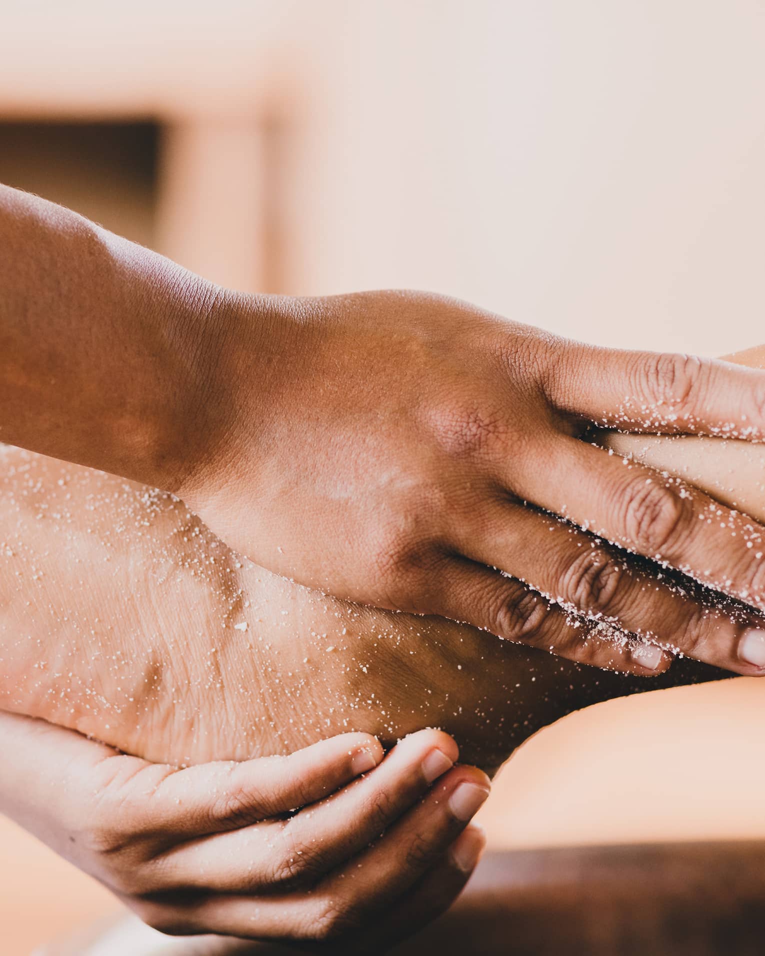 Hands hold a person's foot and ankle in a spa
