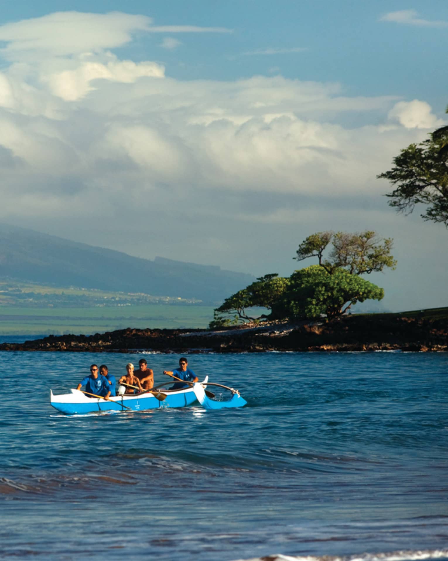 Group of people arrive on shore in an outrigger canoe