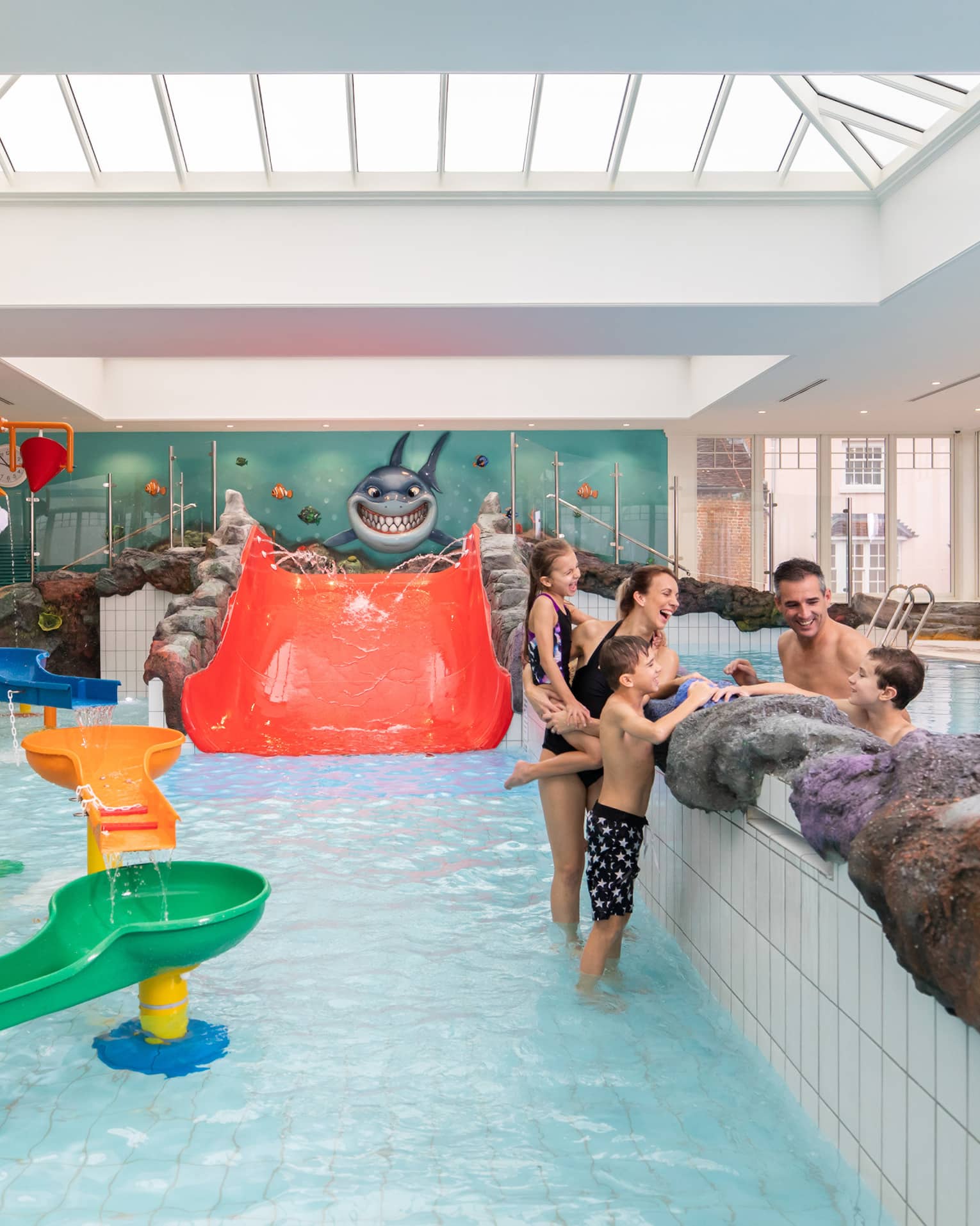 Family talking while standing in Sharkie's colourful indoor pool