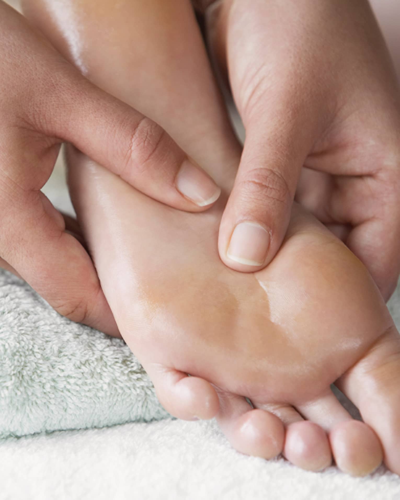 Close-up of hands massaging pressure points on feet