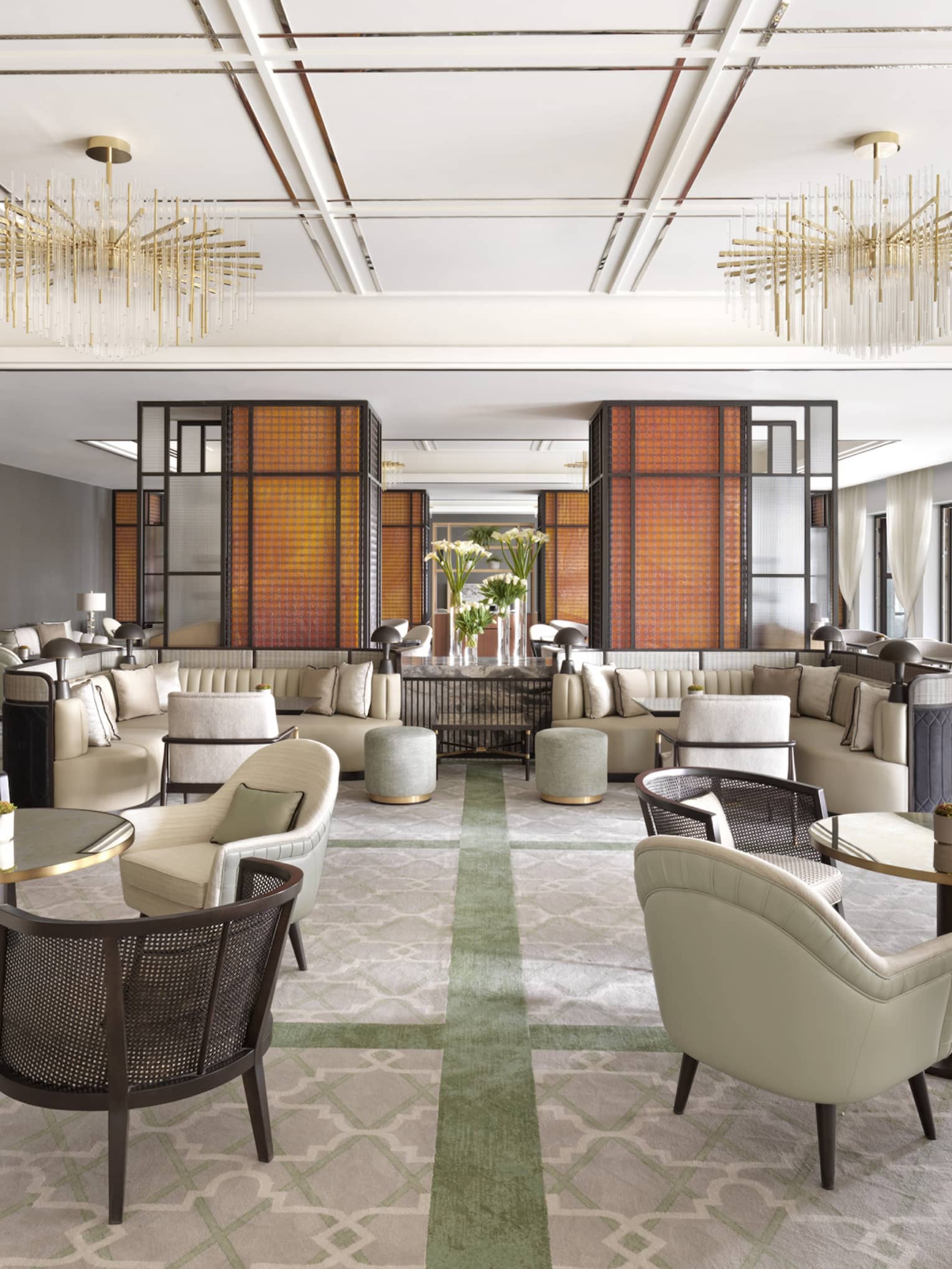 A sitting room with several white and black chairs set up for conversation. 