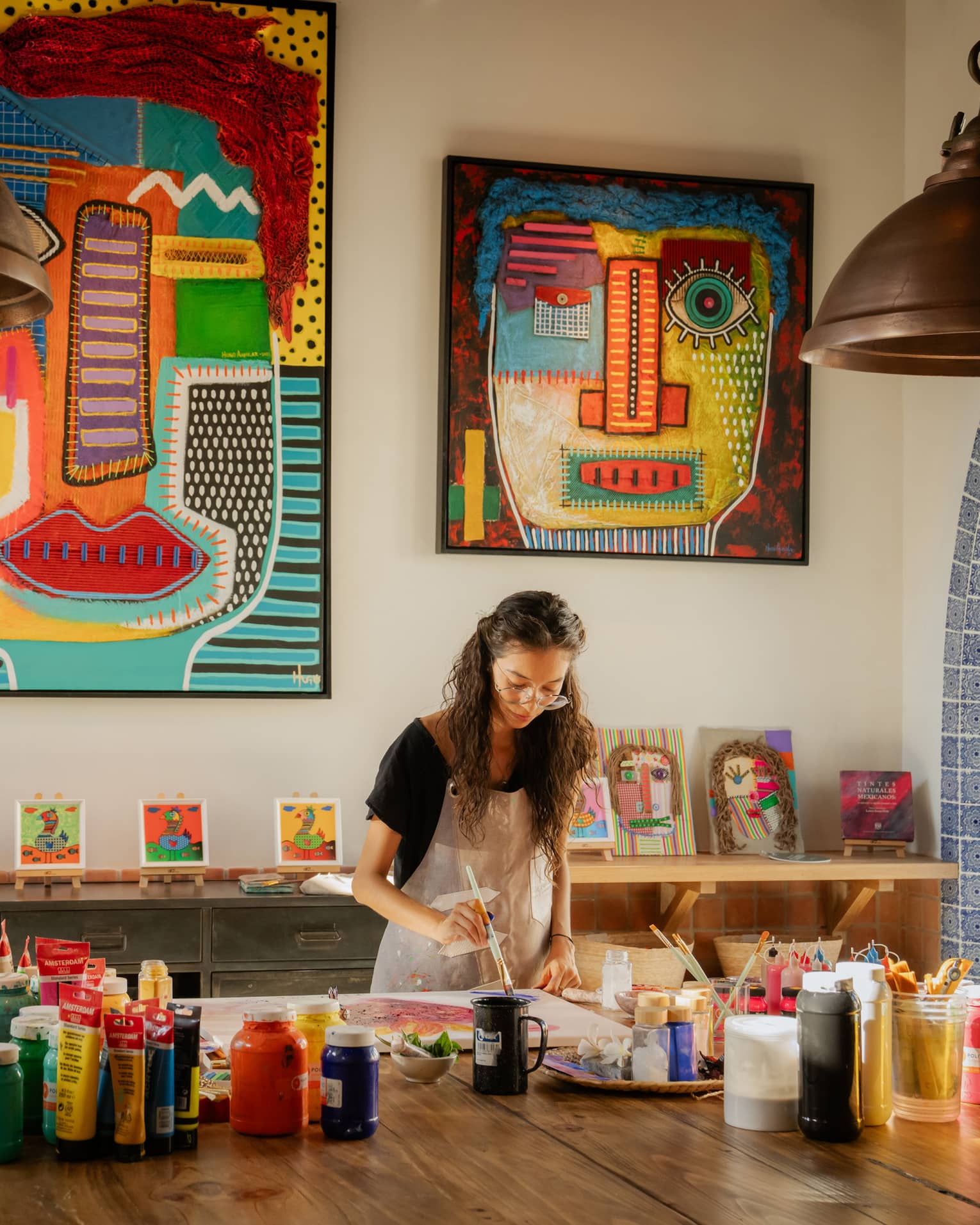 Woman paints in colourful art studio at luxury resort
