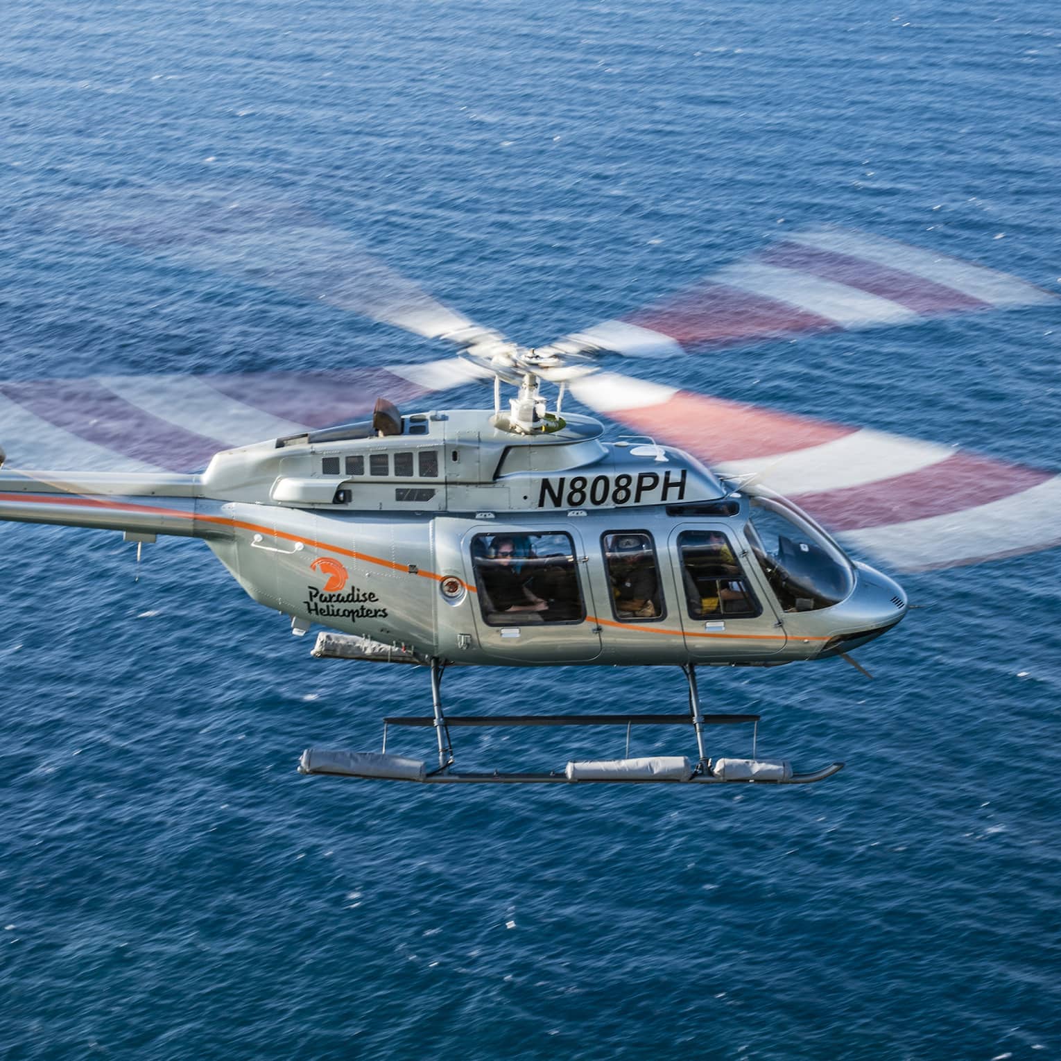 Helicopter flying over blue ocean