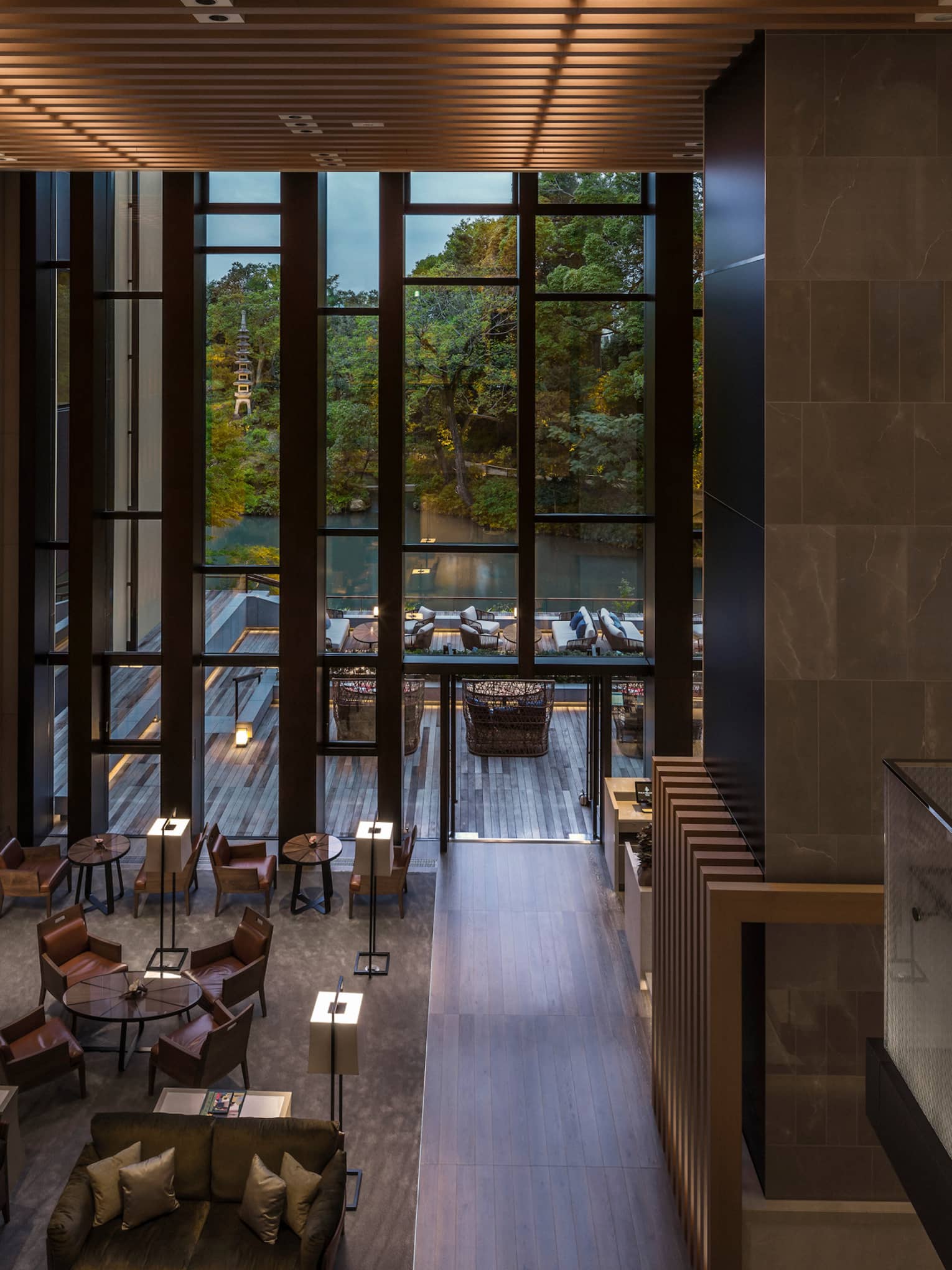 Looking down from soaring ceilings over Brasserie restaurant dining room, wood wall with lights