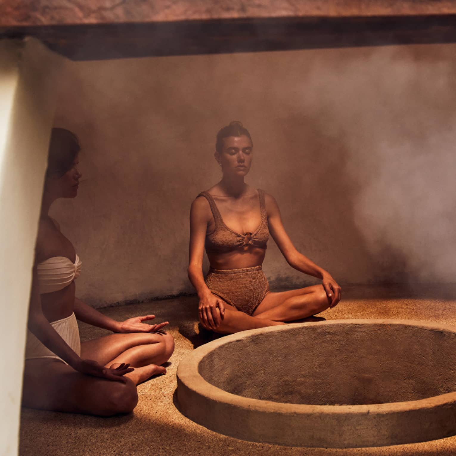 Three people sitting in a heated room with steam.