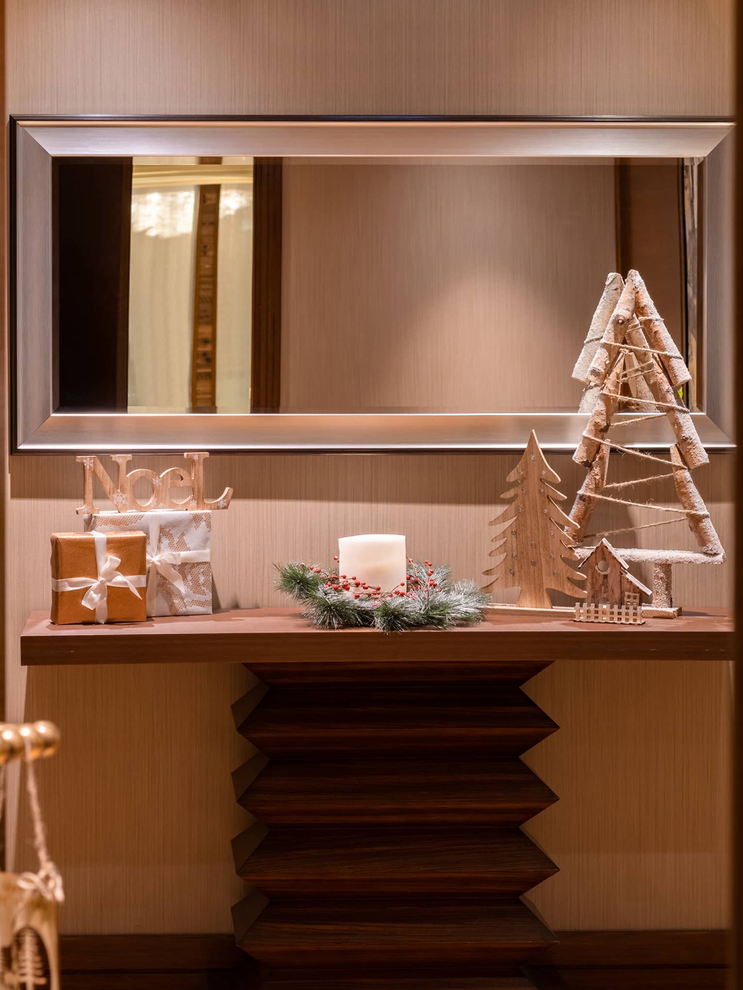 A shelf and a mirror with holiday decorations.