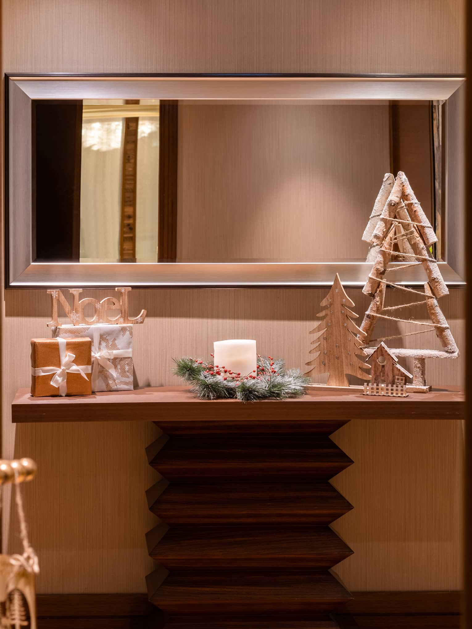 A shelf and a mirror with holiday decorations.