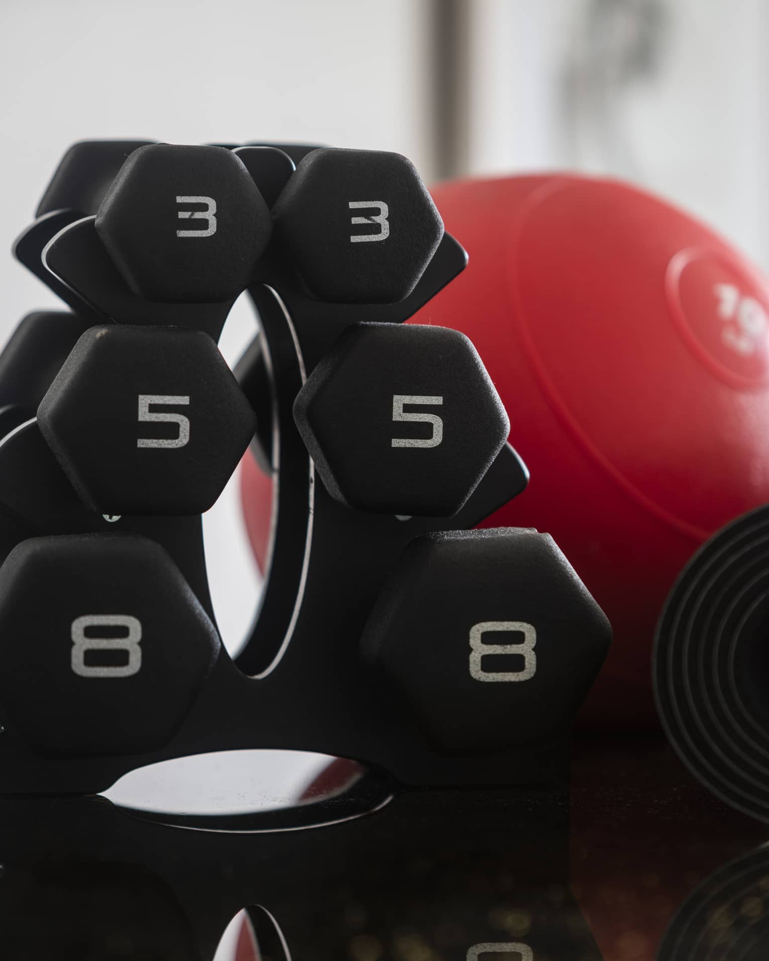 A set of free weights and a red weight ball.