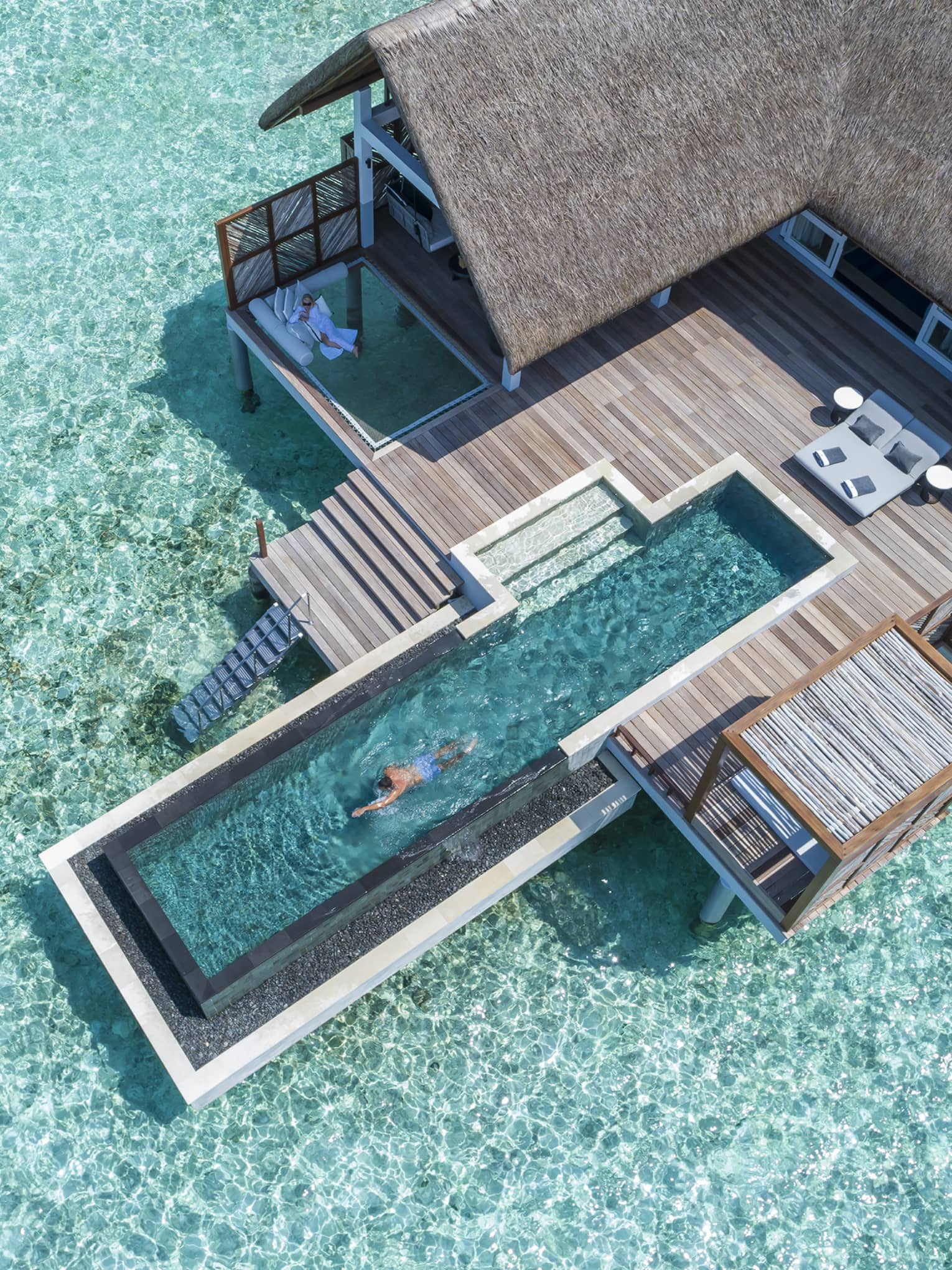 Aerial view of water villa with long swimming pool over lagoon
