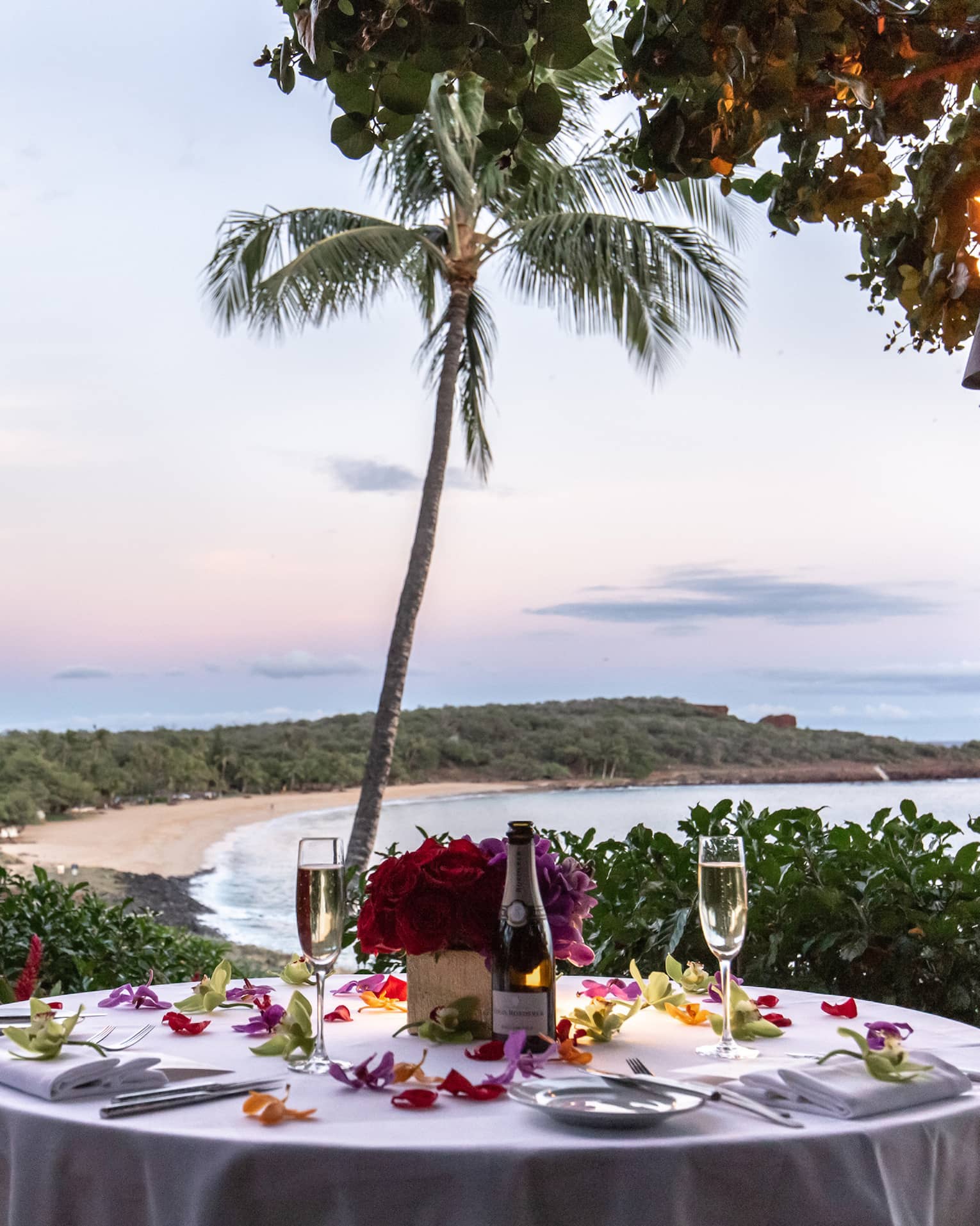 Round dining table set for two outside overlooking tropical bay