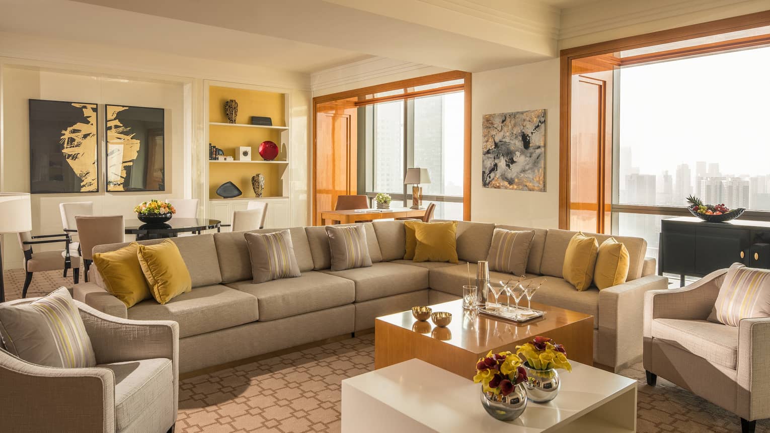 Four Seasons Suite long sofa sectional with yellow pillows, tables, large picture windows