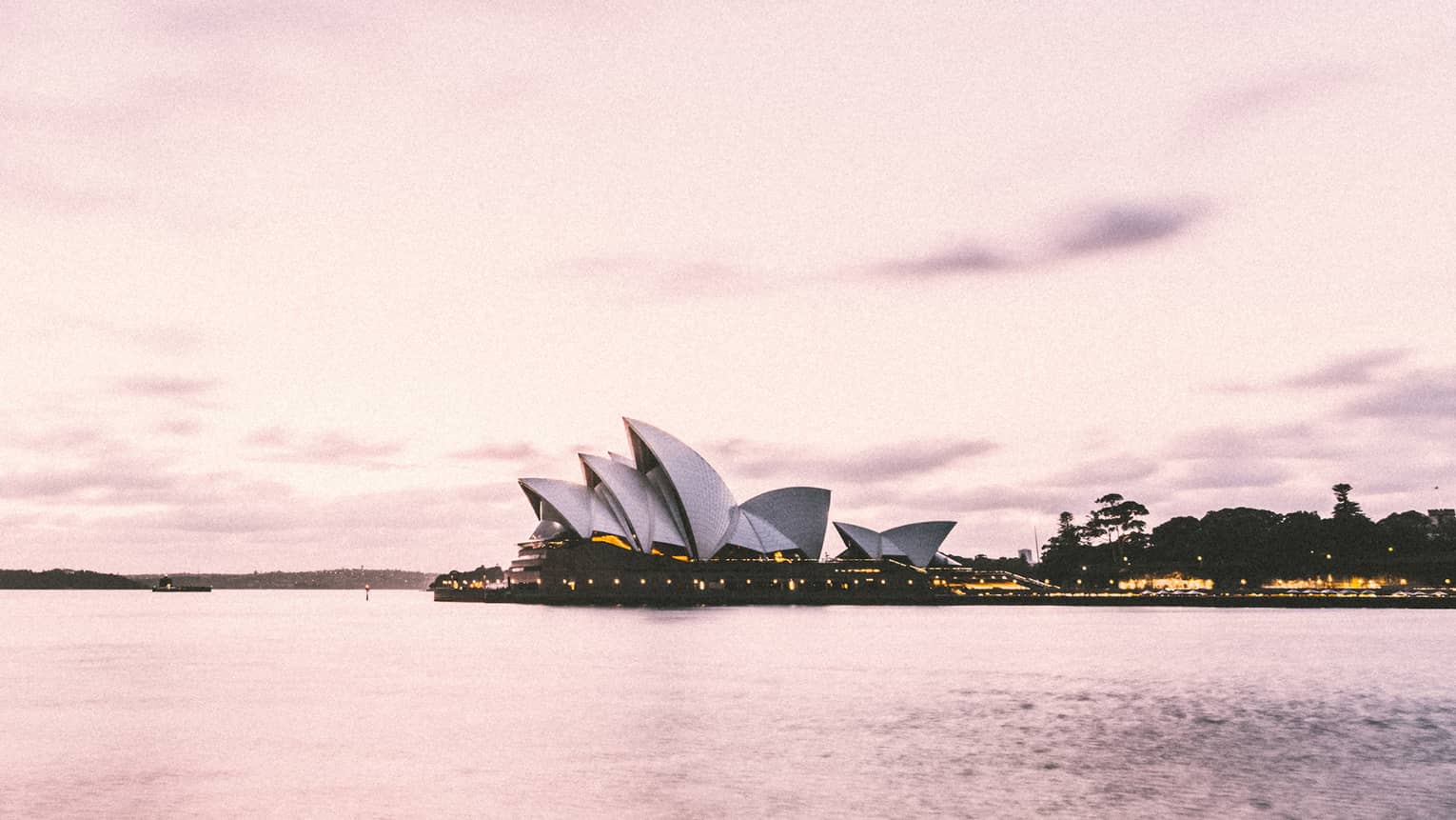 Sydney Harbour's iconic Opera House building on water, pink hue