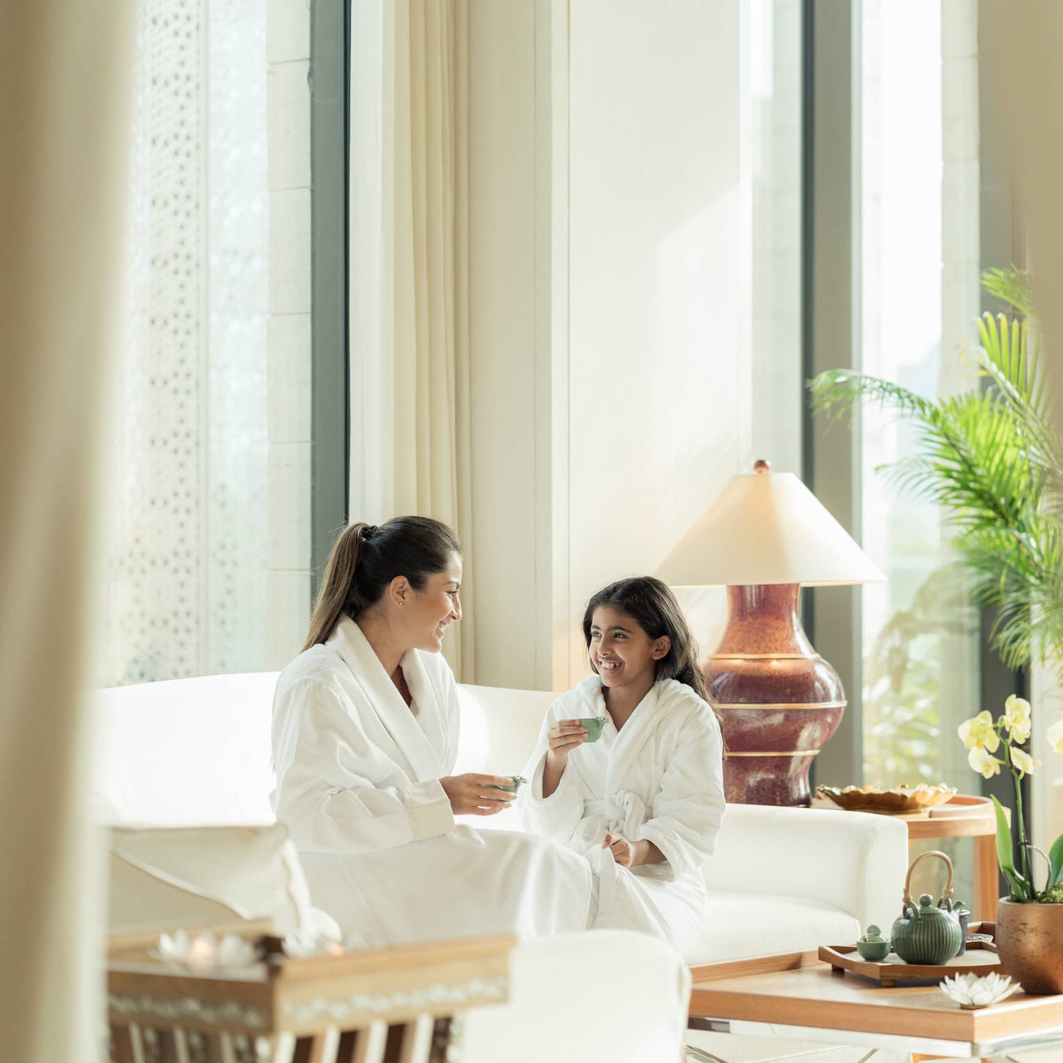 Mom and daughter enjoy tea in luxury hotel spa