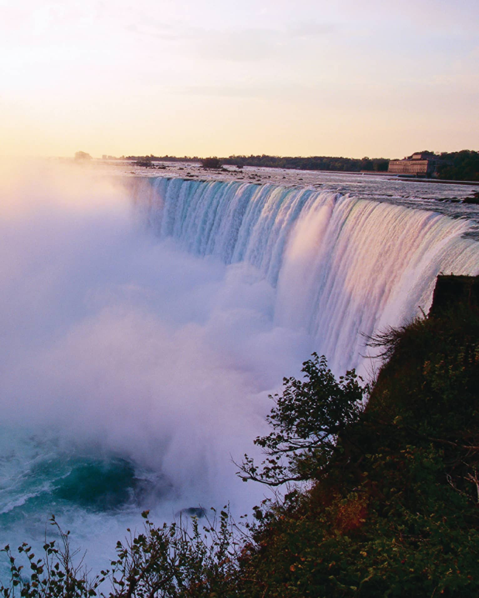 Mist rising from Niagara Falls waterfall at sunrise 
