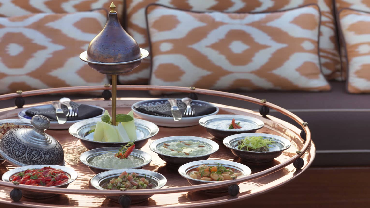 Mezze appetizers in small dishes on large brass tray