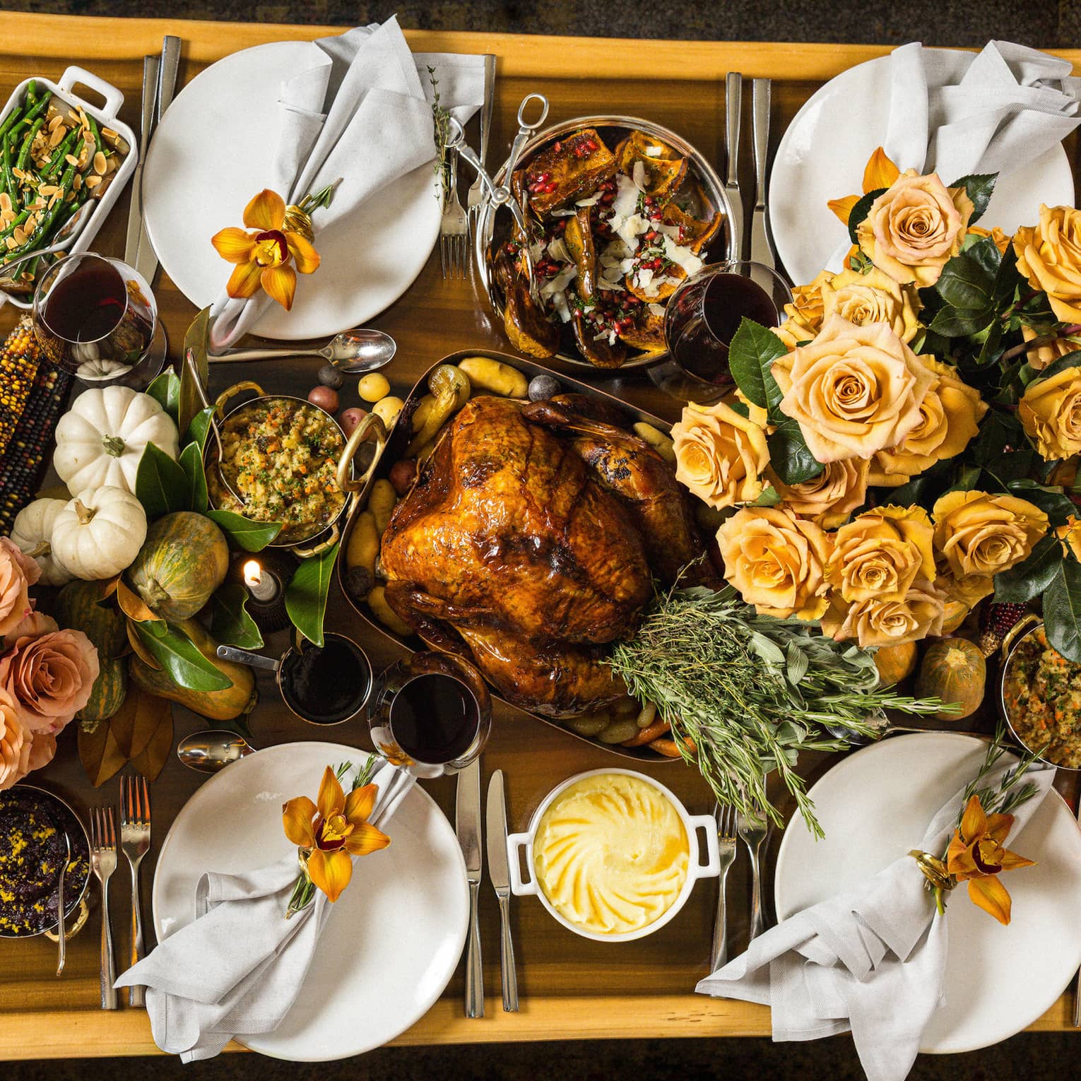 Overhead view of rectangular live-edge wooden table filled with a holiday feast