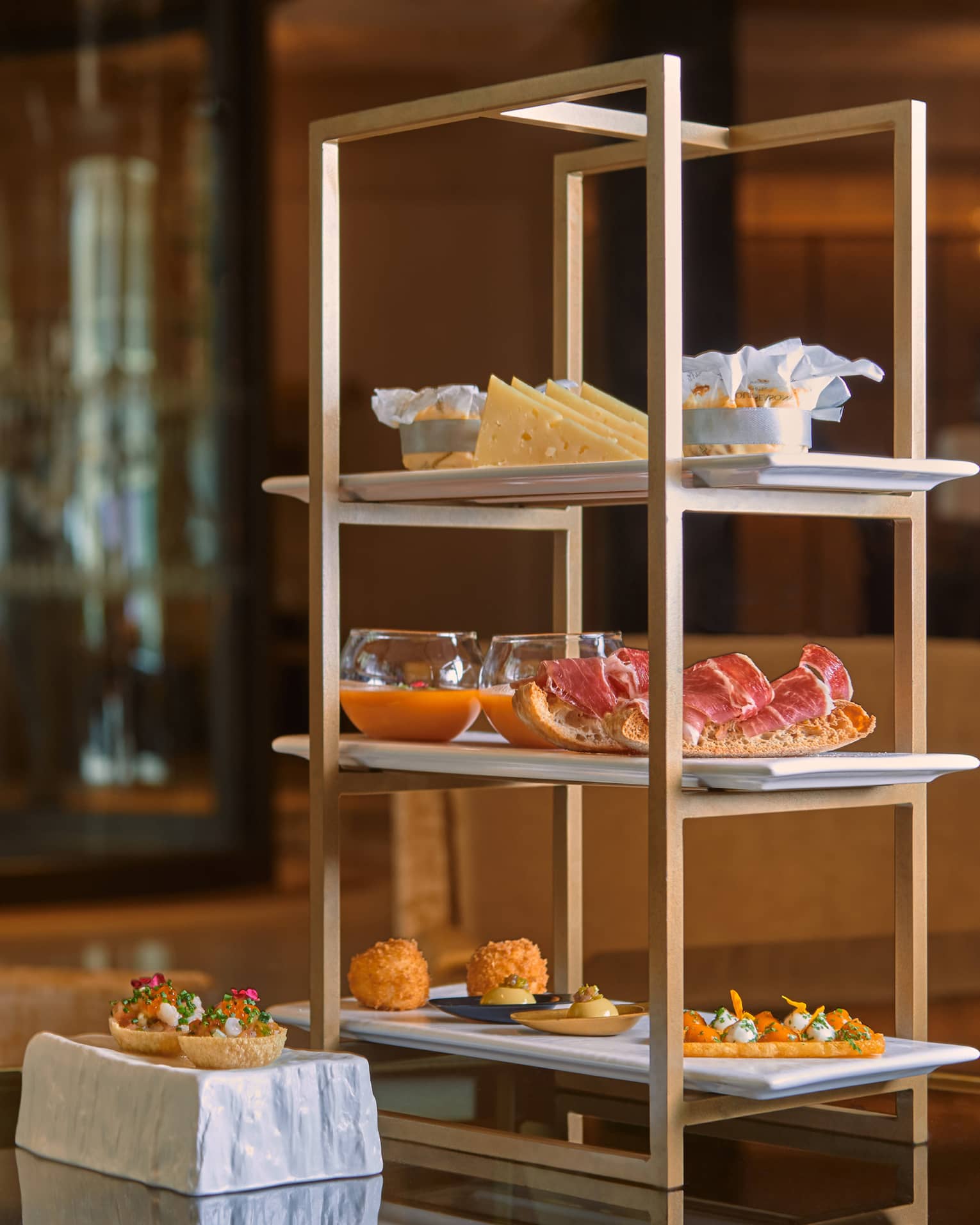 Tapas on a three-tiered stand atop dining table