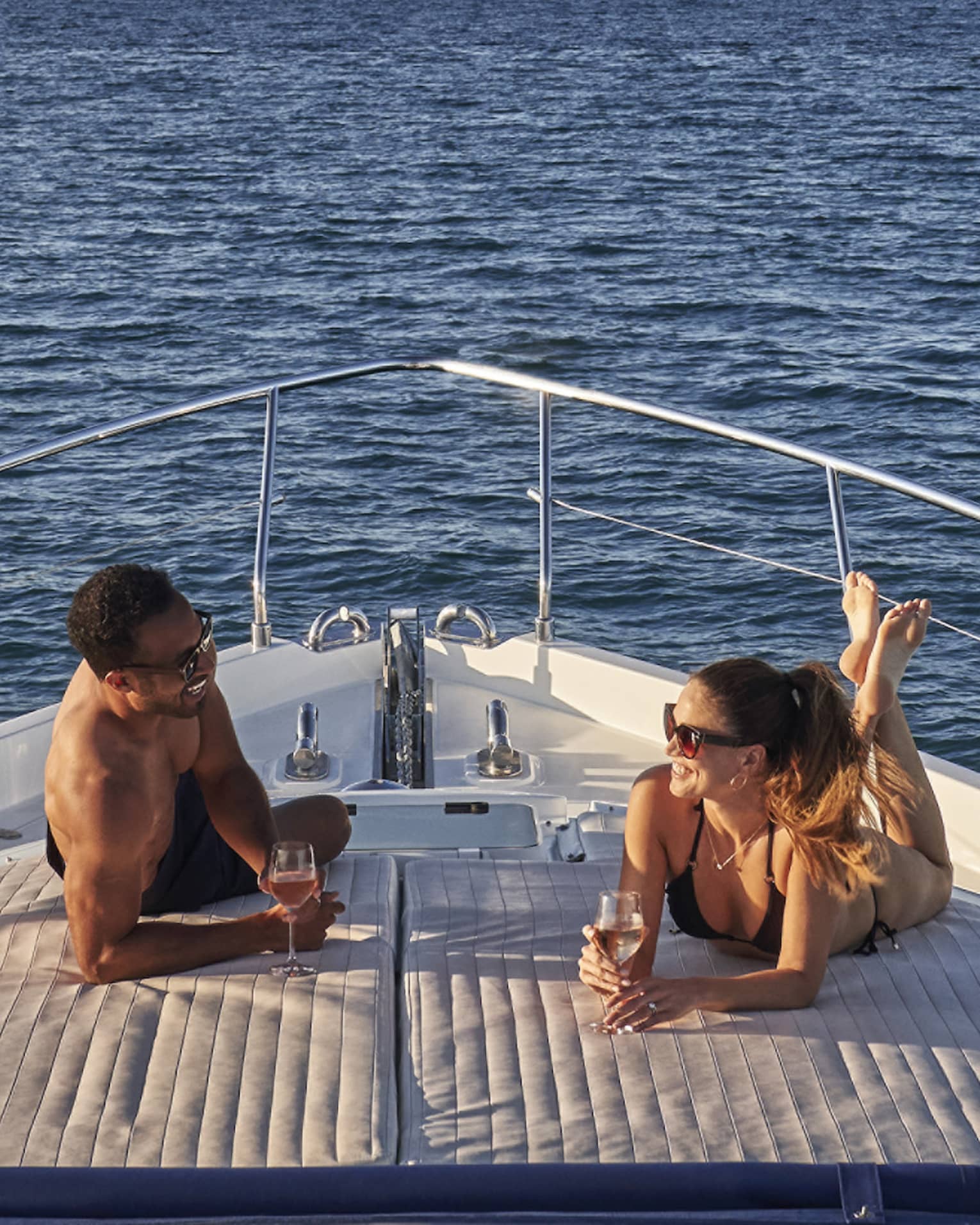 Man and woman lay on front of yacht