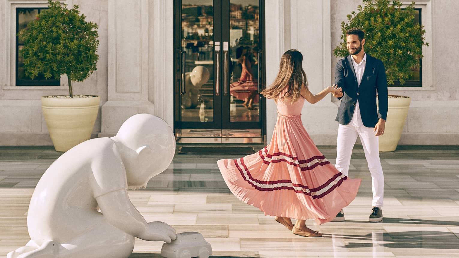 Couple dancing in front of historic hotel building