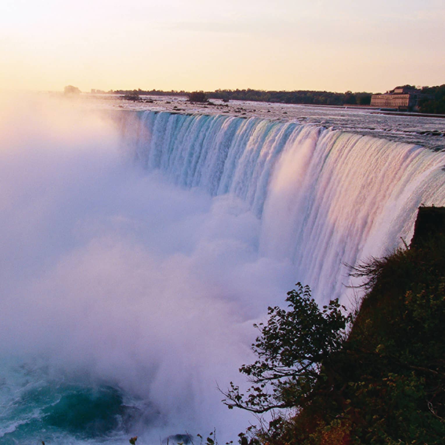 Mist rising from Niagara Falls waterfall at sunrise 