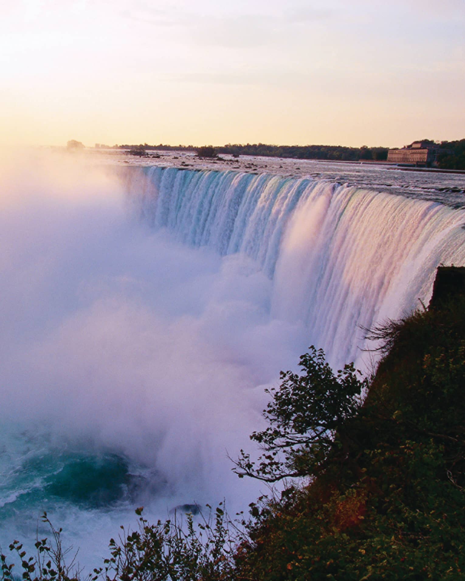 Mist rising from Niagara Falls waterfall at sunrise 