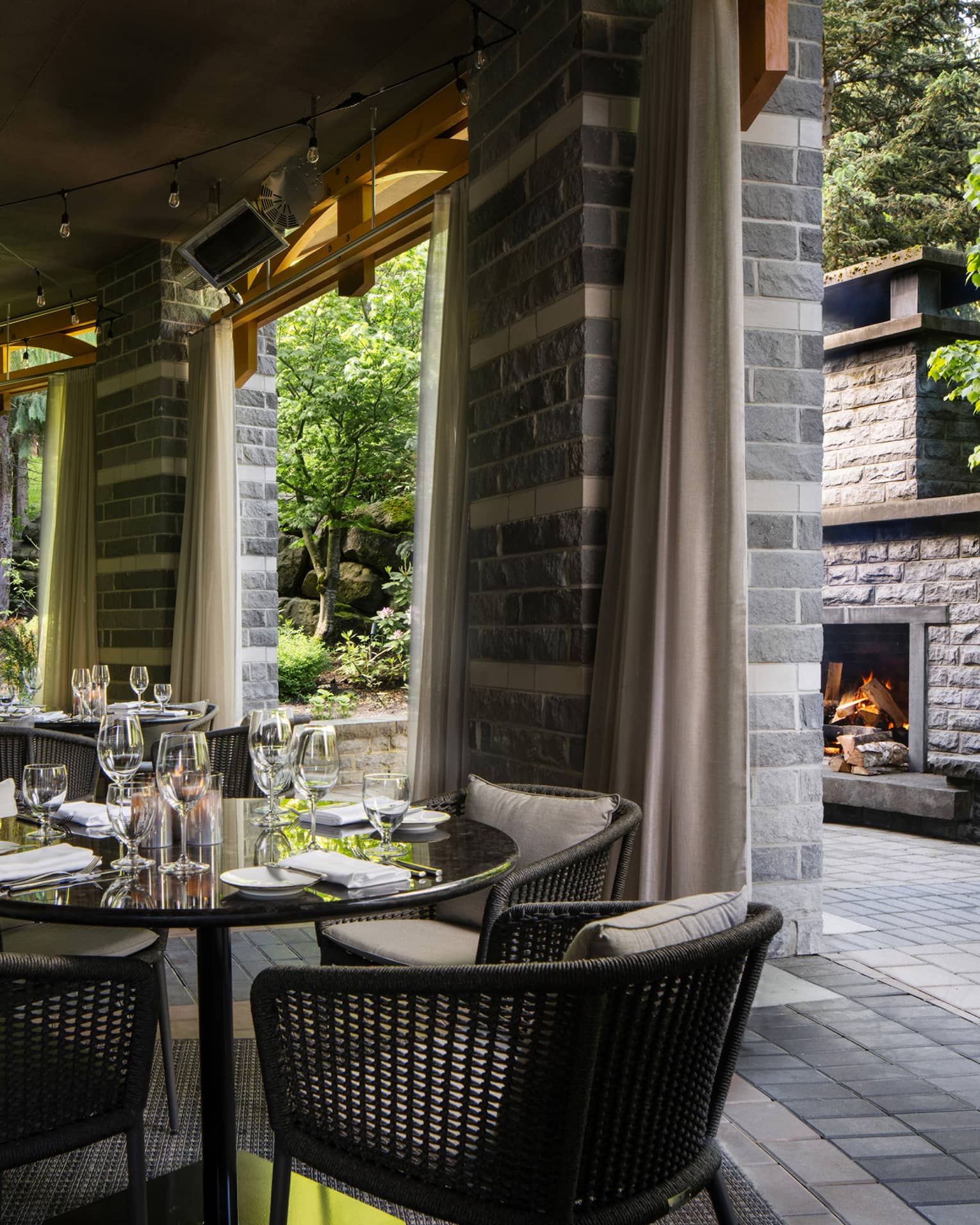 A patio area with tables and a fireplace.