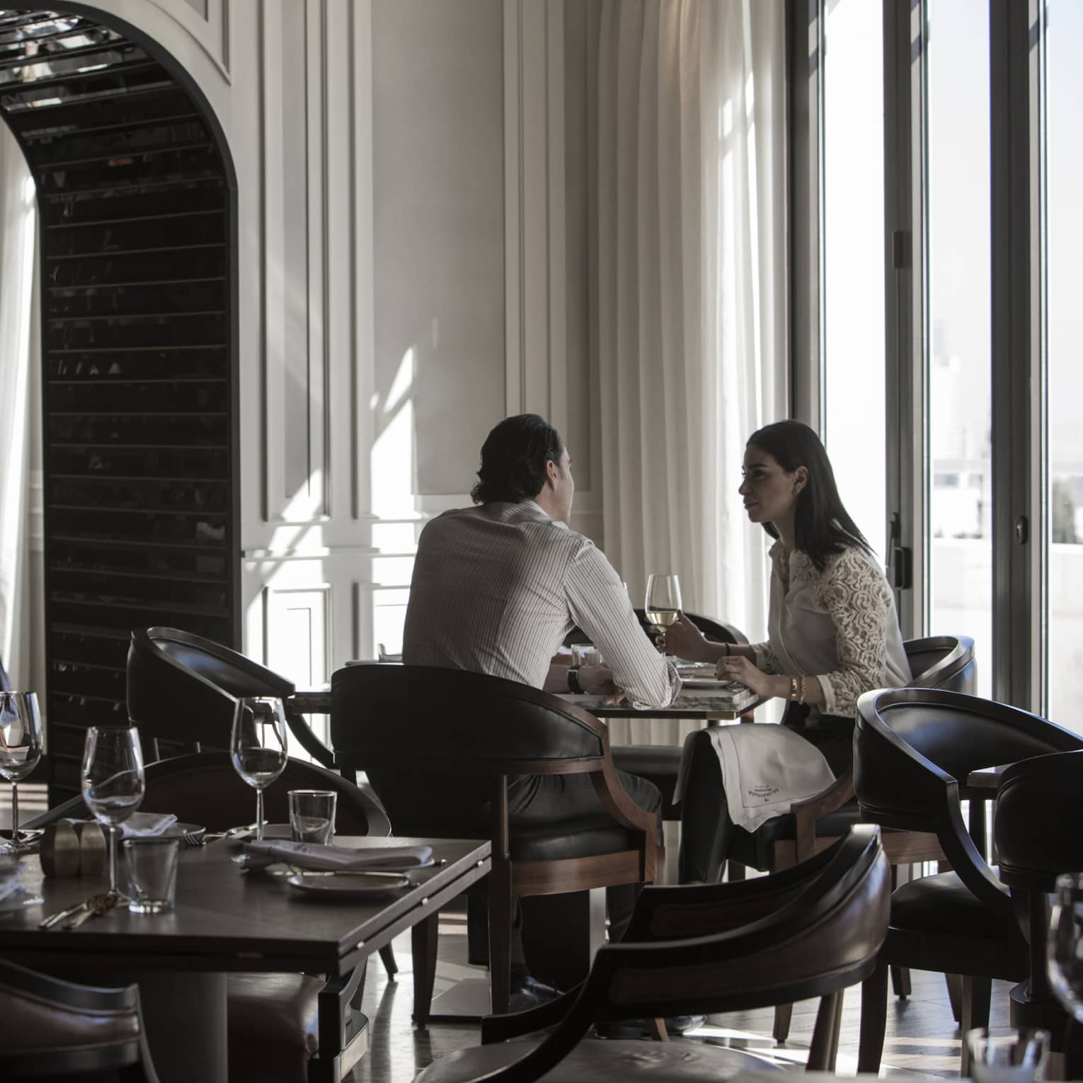 Couple dines by sunny window in modern La Capitale dining room