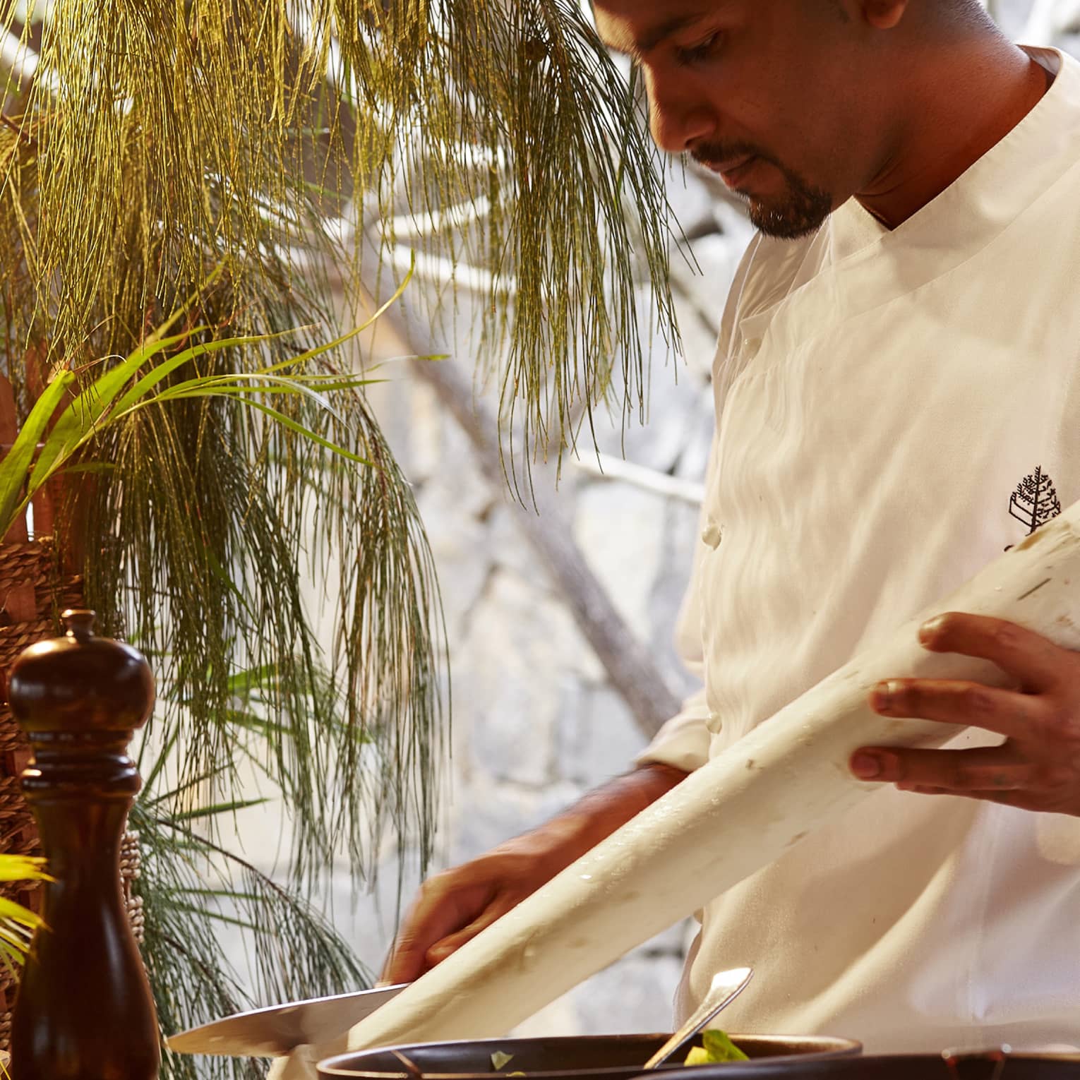 Zilwa Night, chef in white uniform carves long white stick by pepper mill