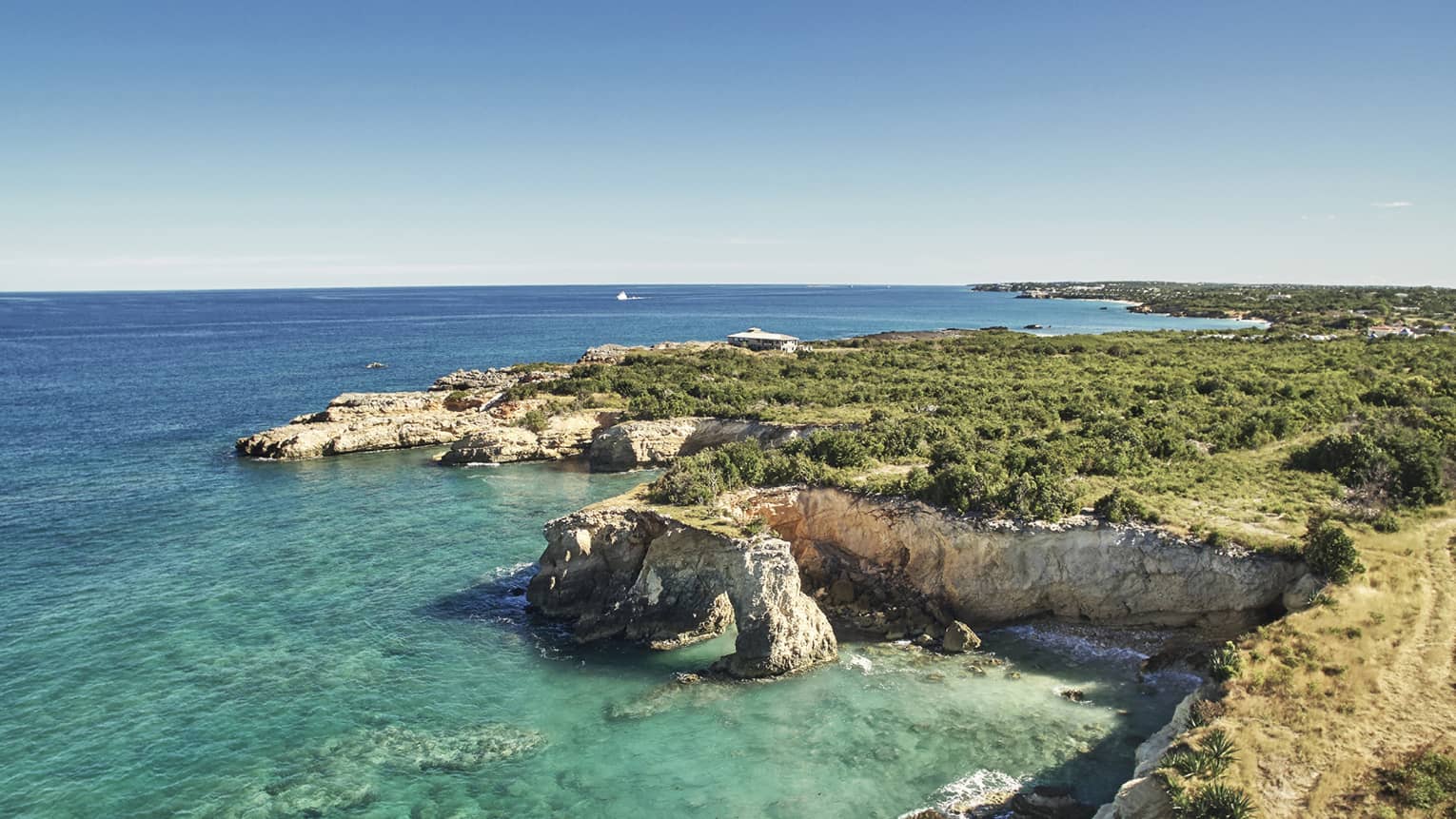 Aerial view of rocky cliffs over turquoise bay