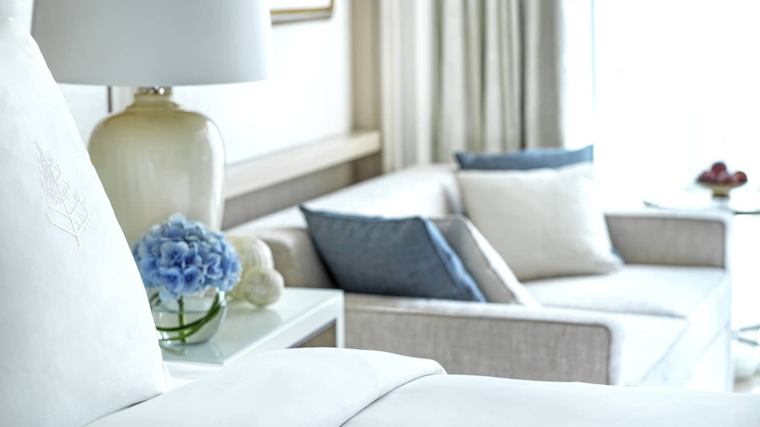 Four Seasons bed, nightstand with lamp, and two-seat sofa