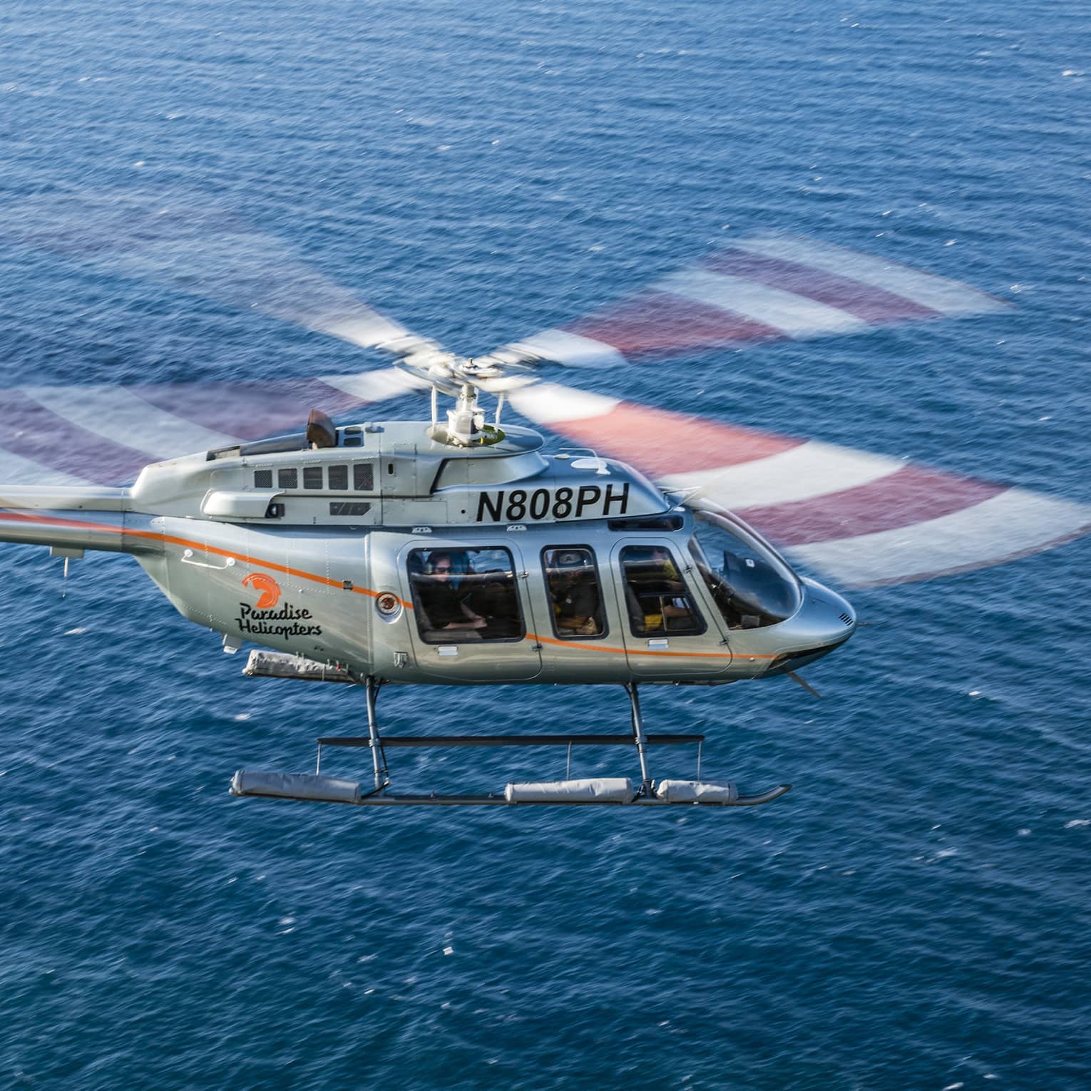 Helicopter flying over blue ocean