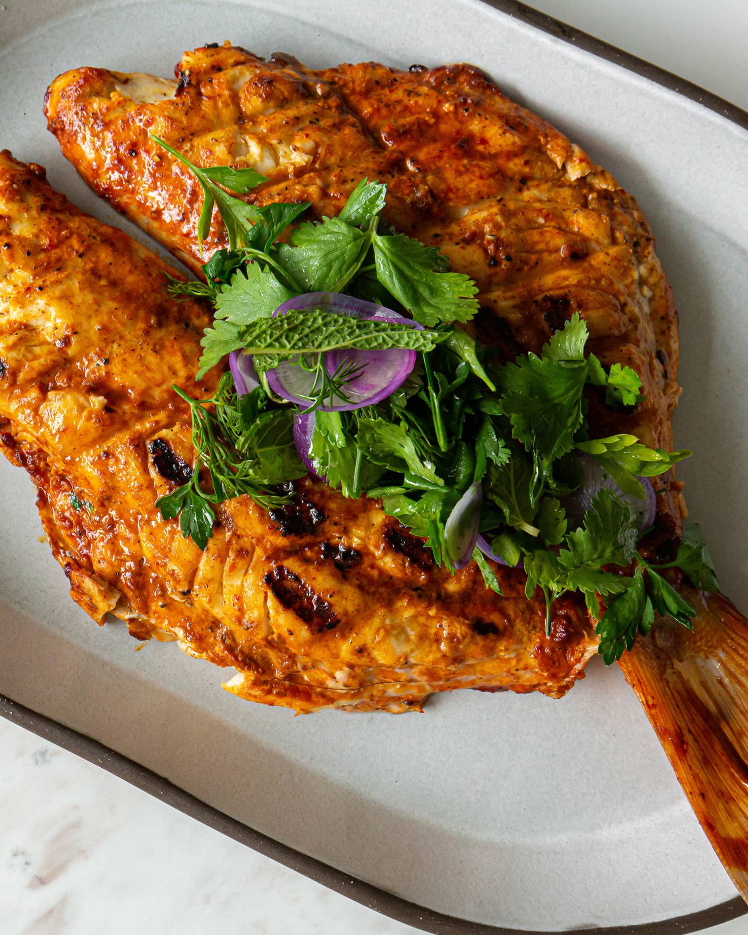 Cooked fish on a white plate.