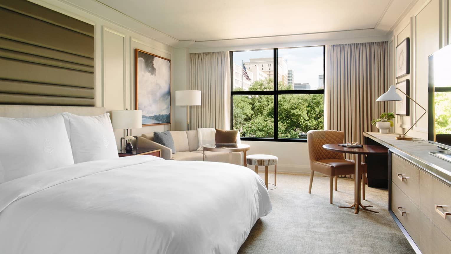 City-View Room bed, framed painting over sofa, tables by window
