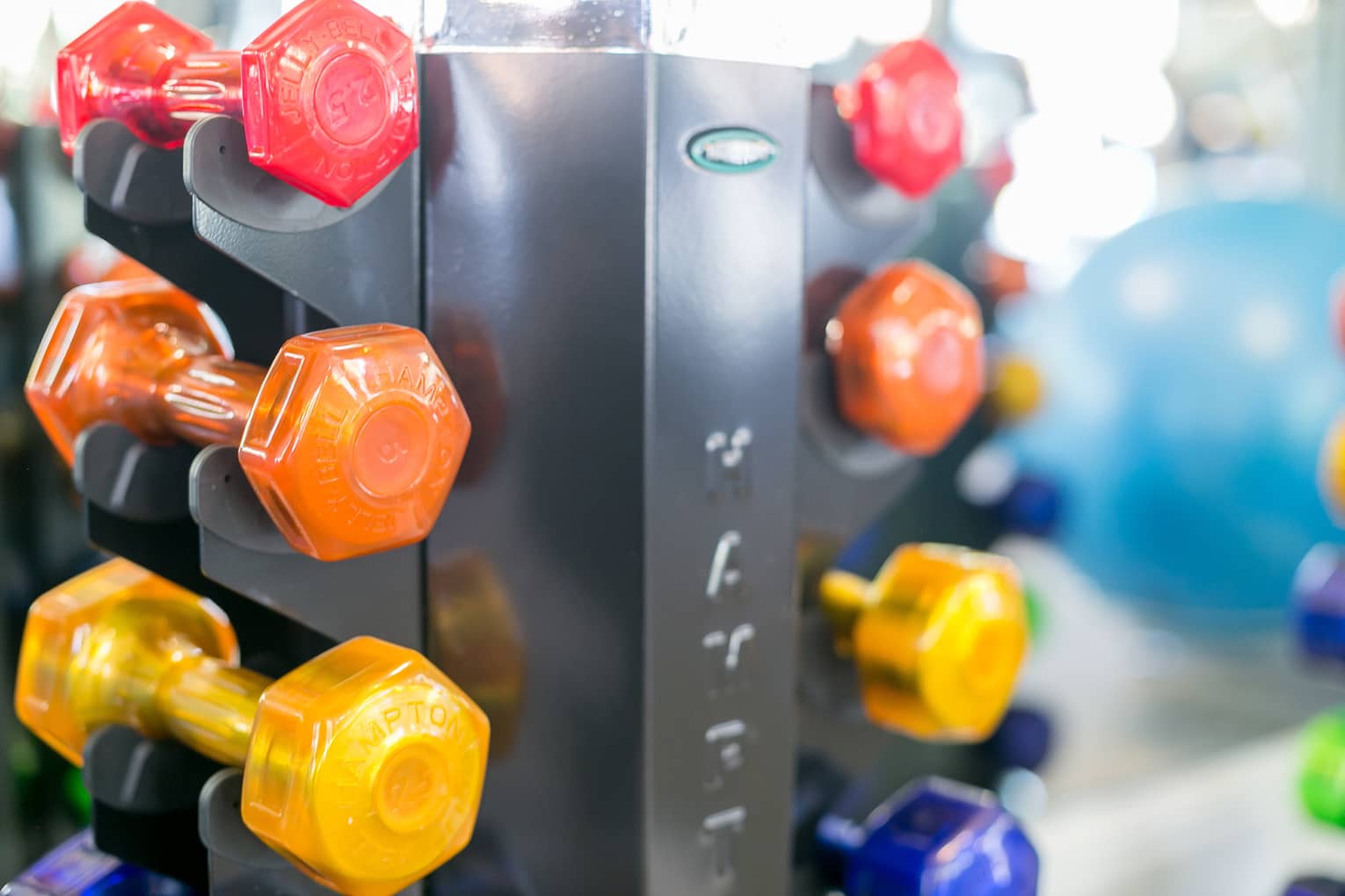 Colourful hand weights stacked in holder