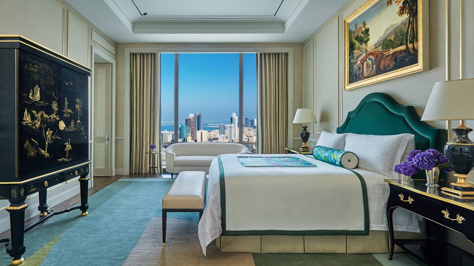 Presidential Suite side view of bed, bench at foot, decorative black dresser, window with city view