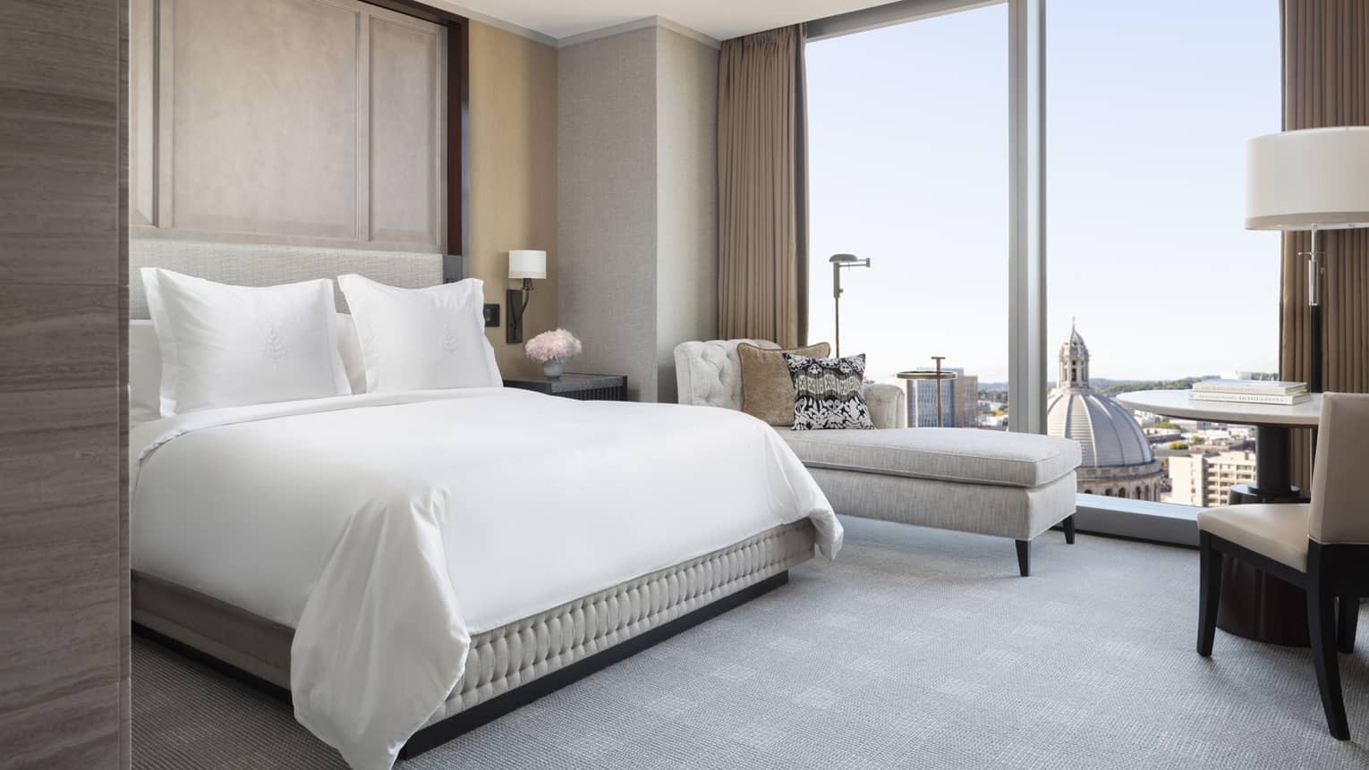 guests room with queen bed, lounge couch, desk area and floor to ceiling window at four seasons hotel boston one dalton 