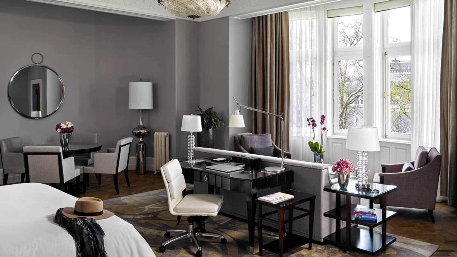 River-View Park Suite bed with hat and scarf, desk, loveseat and armchairs in front of large picture window