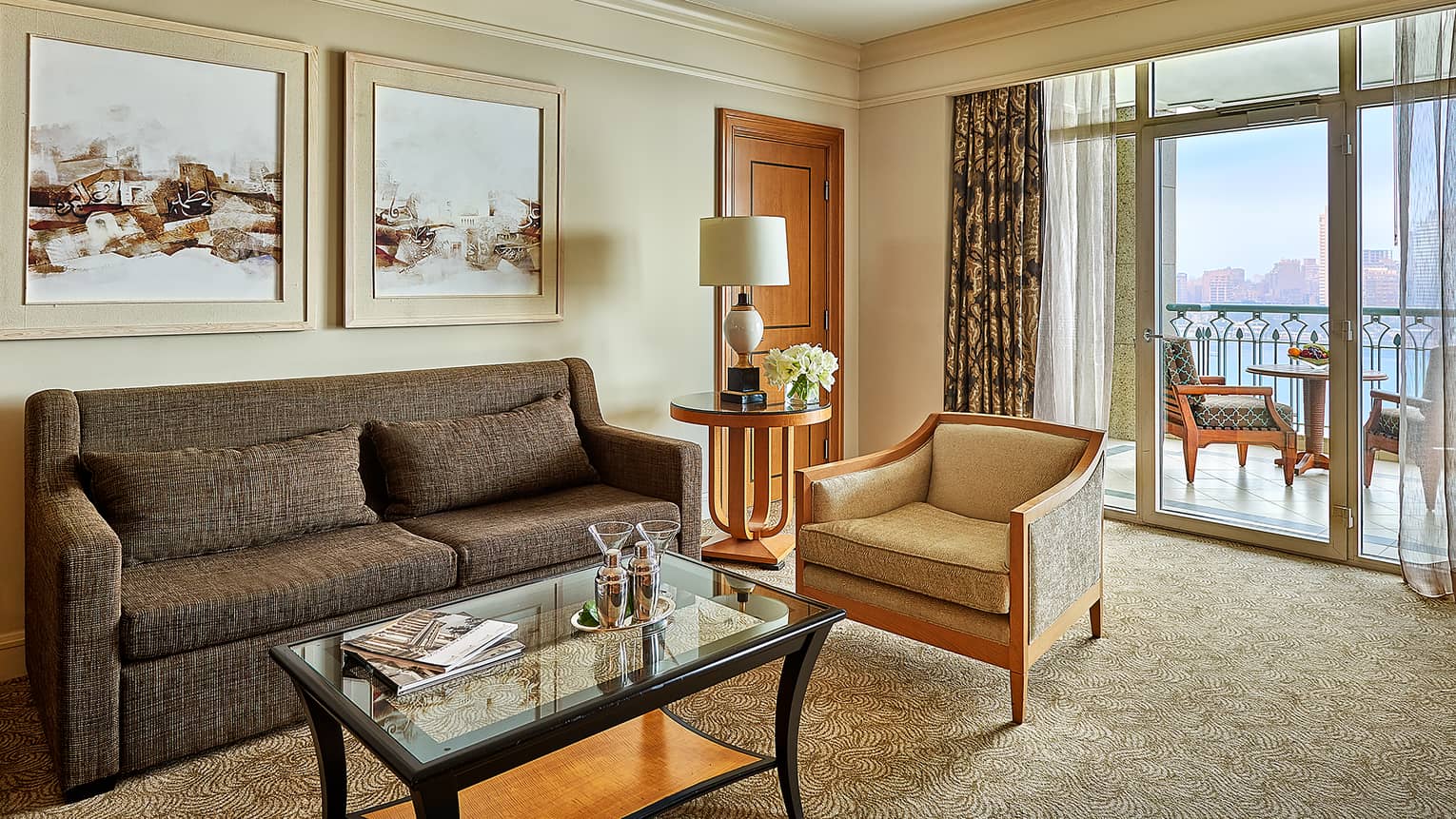 Diplomatic Suite living room with modern grey sofa and art, martini glasses and shakers on coffee table